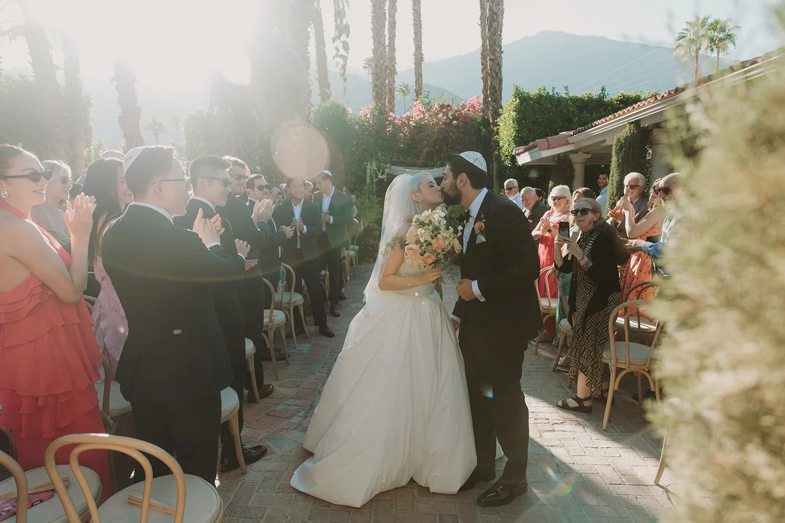 Bride and groom kissing in the aisle