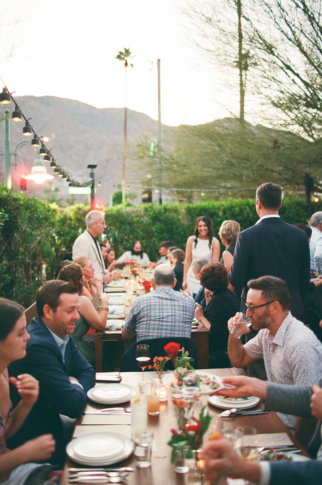 Wedding guests sitting at long table outside