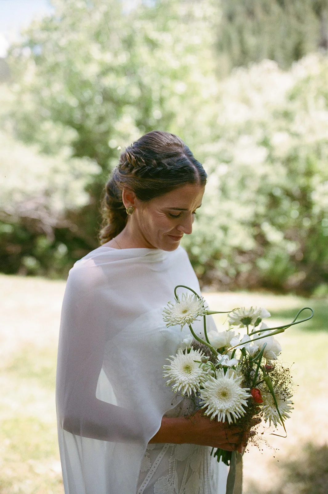 Bride smiling down at her bouquet
