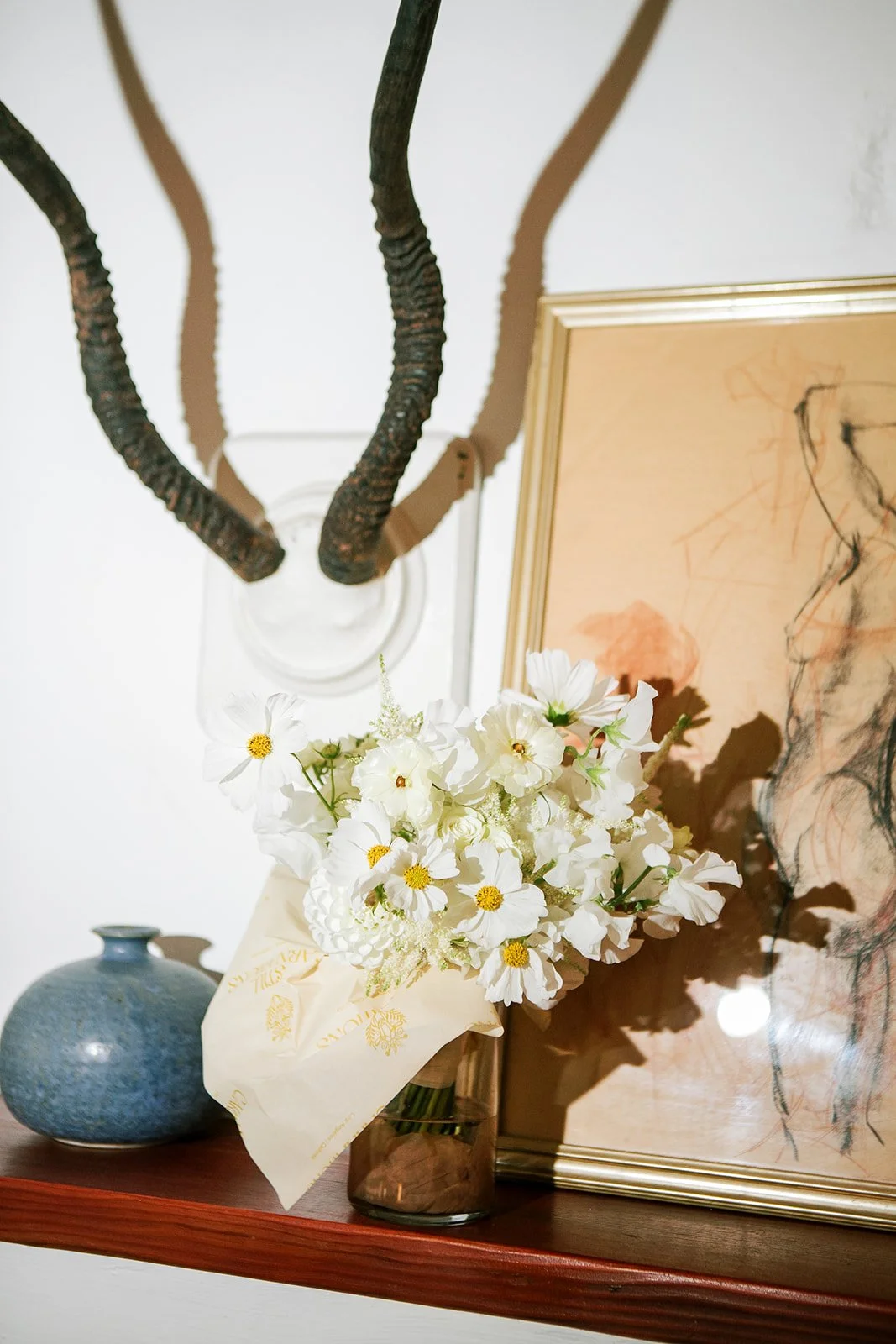 Bridal bouquet on the mantle with antlers behind