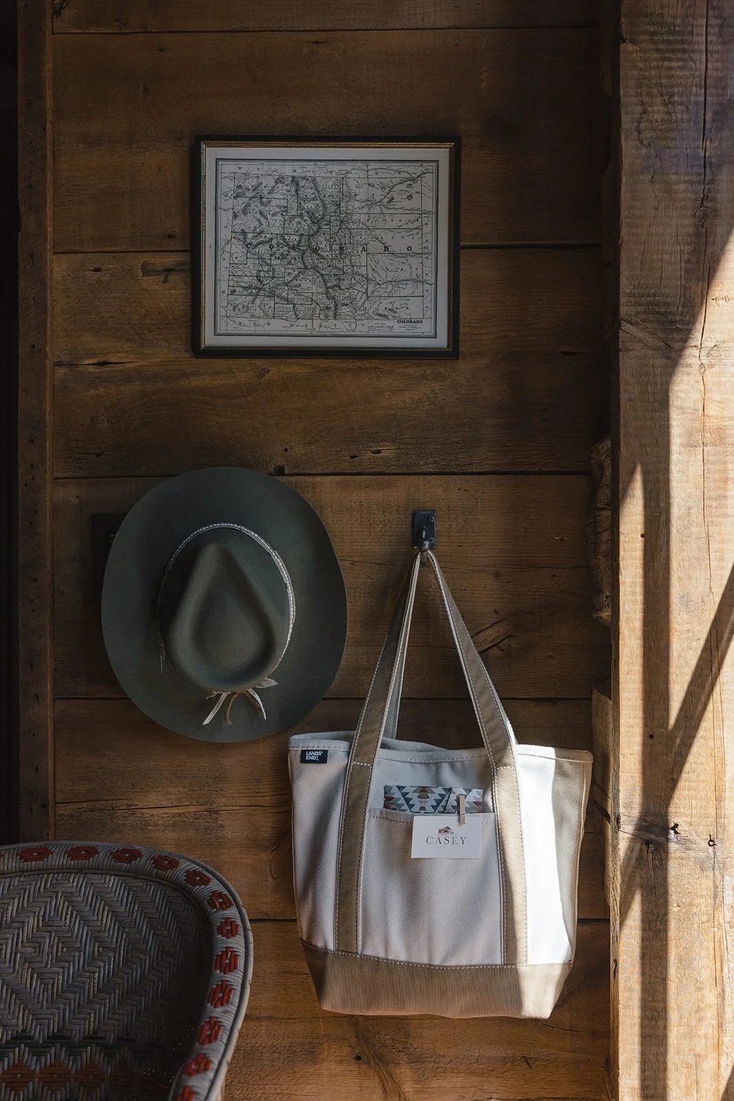 Western hat and tote bag hanging on a wooden wall