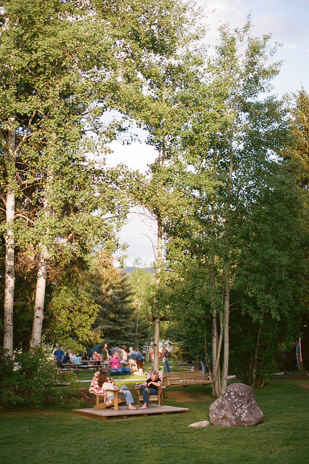 Wedding guests sitting outside in chairs and lounging
