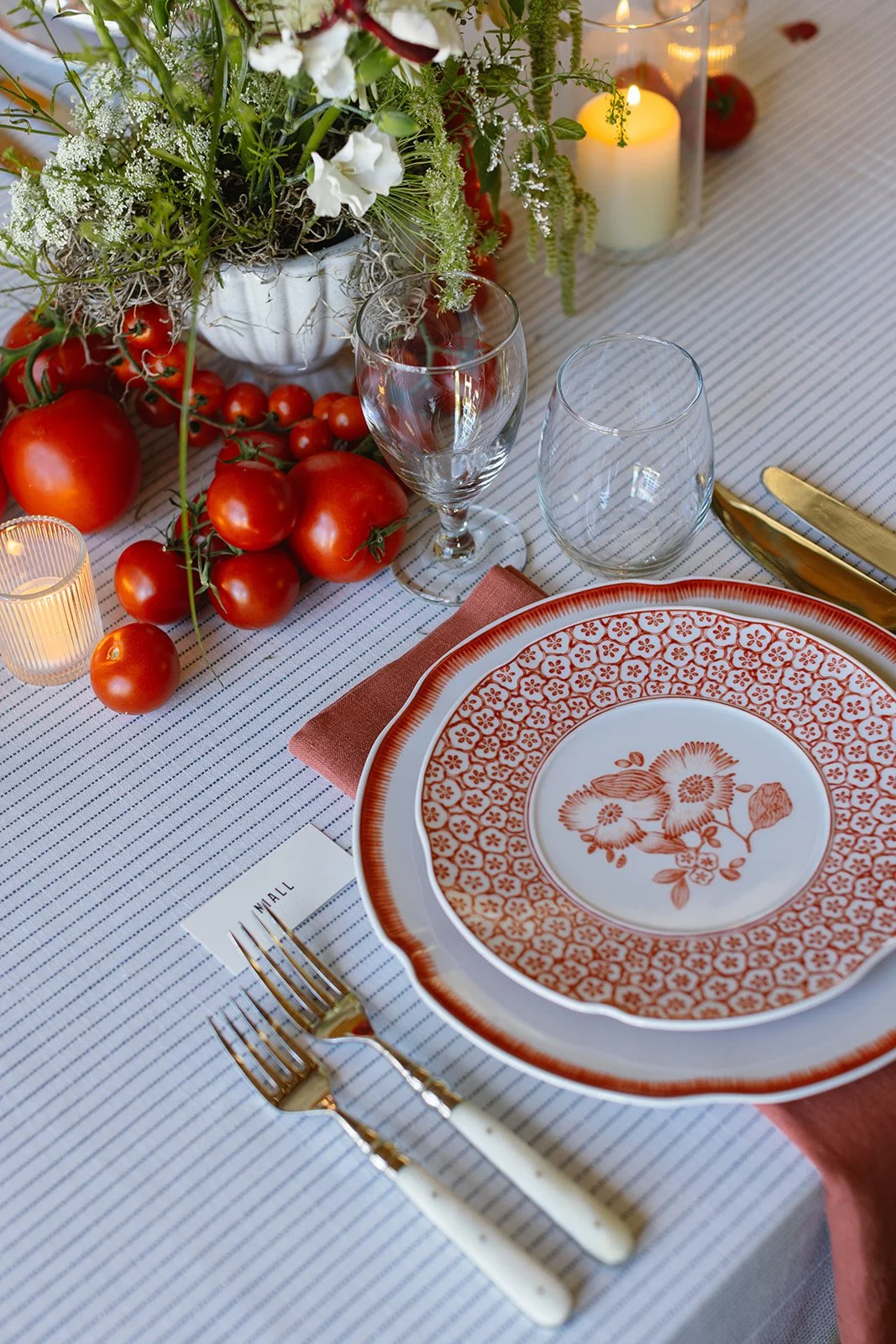Plate setting with name card and floral arrangement of tomatoes