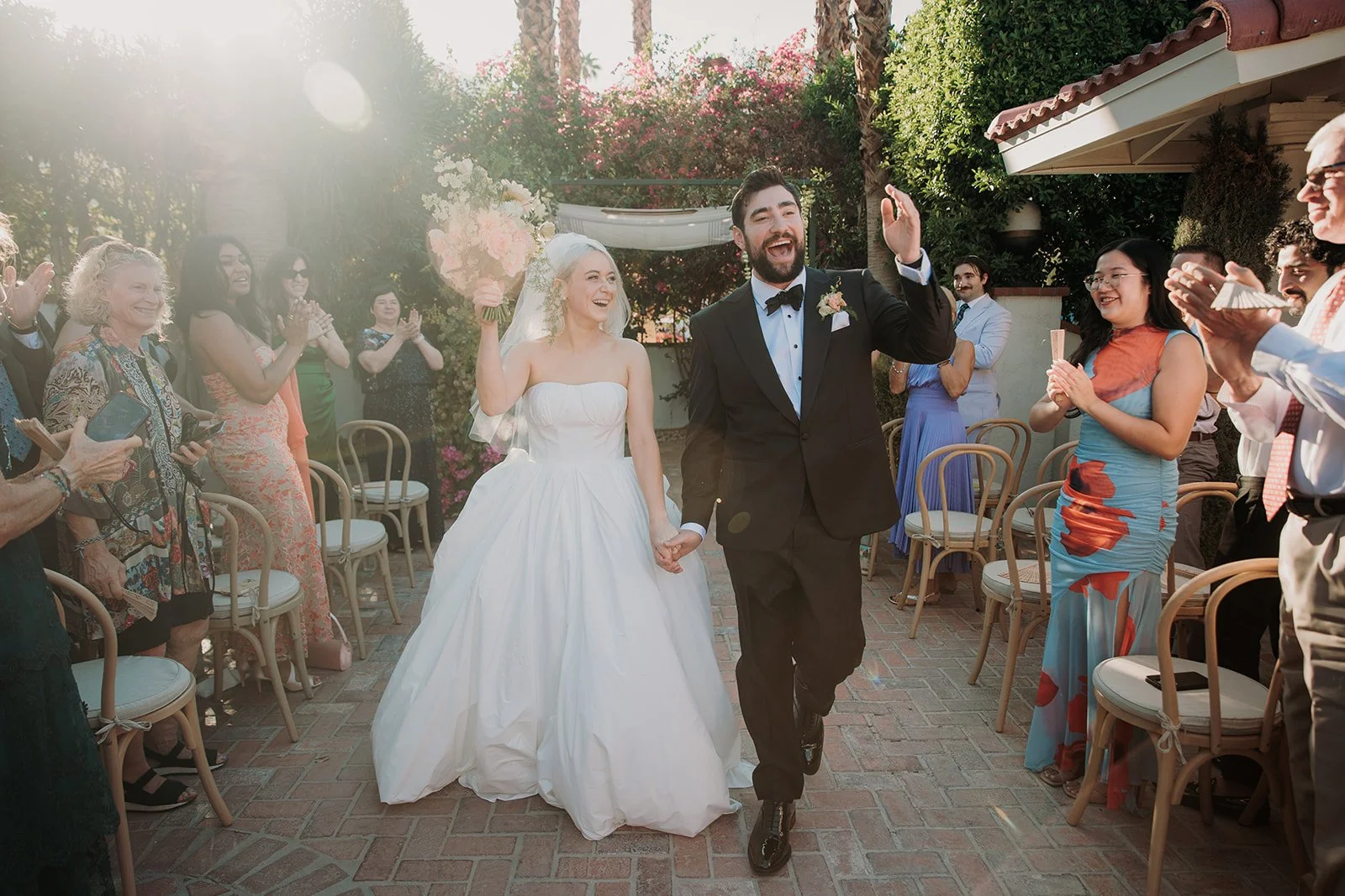 Bride and groom holding hands walking down aisle