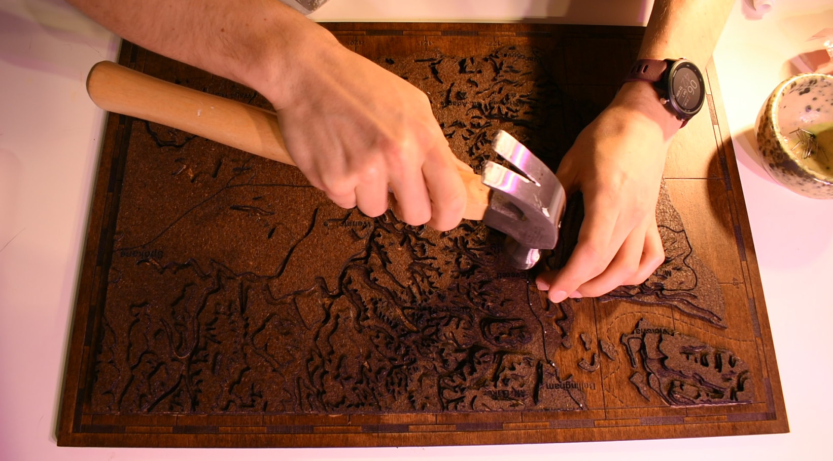  Hammering in the nails (because the first couple layers of cork are too thin to get them snugly in) that will hold the string in place 