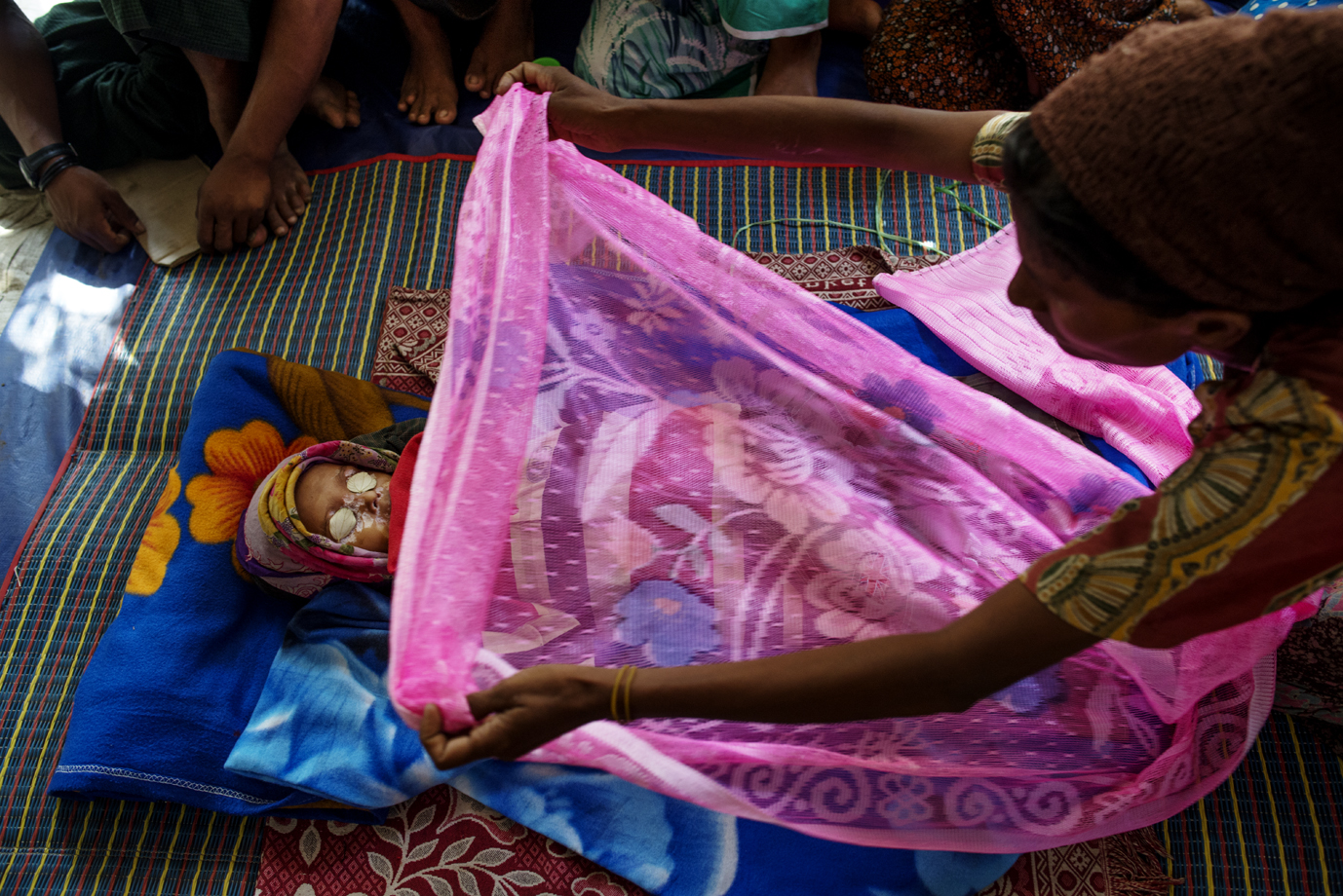  Rohingya mother sweeps a blanket over her deceased son, Sittwe, Rakhine / Burma - 2013 