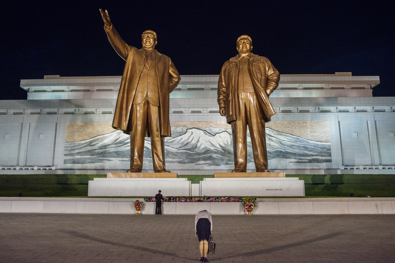  A woman bowing infront of the statues of the deceased leaders Kim il-sung and Kim Jong-il, Pyongyang / North Korea - 2013 