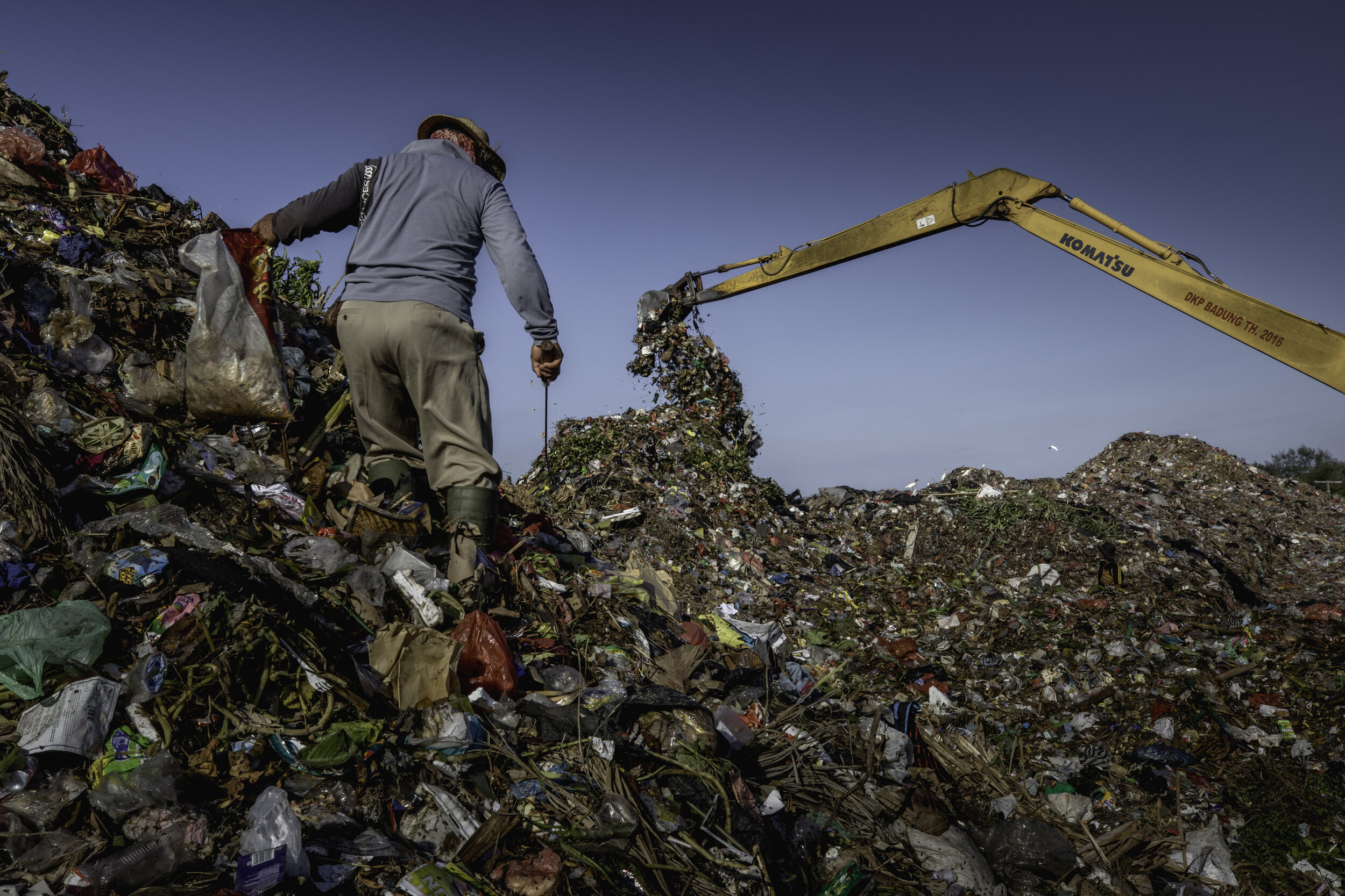  A ragpicker walks trough a mountain of rubbish at a garbage dump in Bali / Indonesia - 2019 