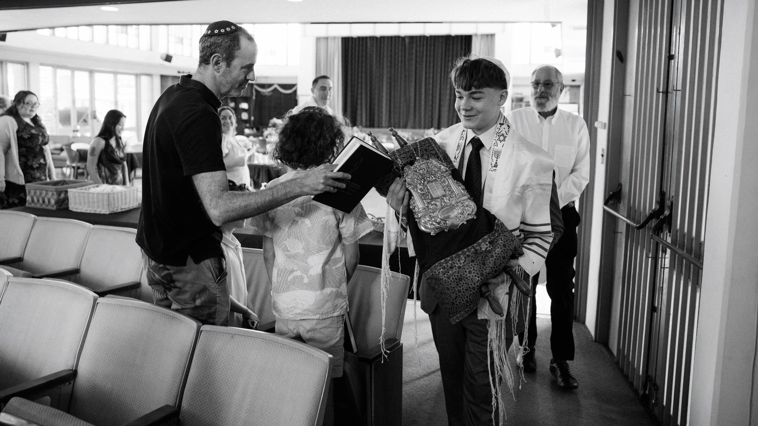 Kevin walking with family during ceremony Temple Emanu-El Oahu and Torah