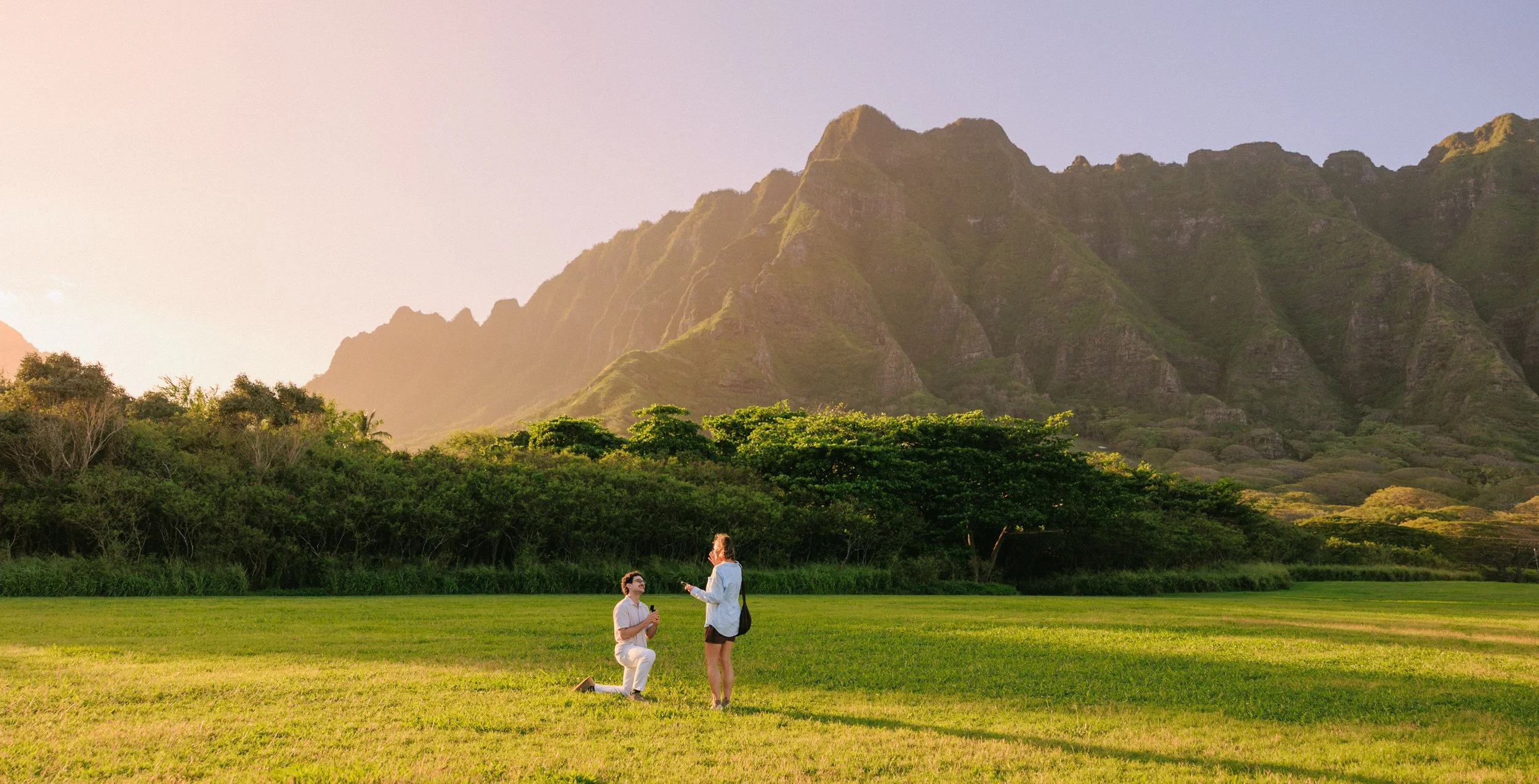 Oahu proposal photography at Kualoa Regional Park featuring a couple moments after a surprise engagement