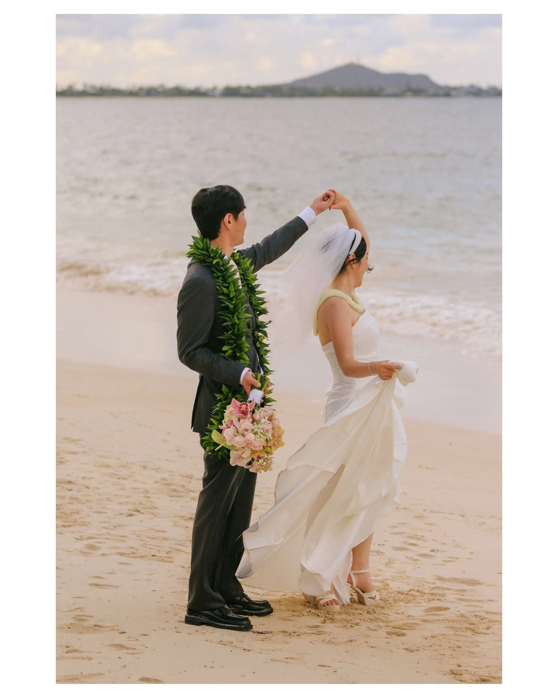 Twirl moment between Tiffany and Sungho during their Kailua Hawaii wedding celebration beach wedding