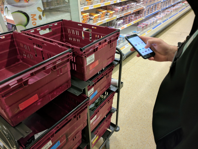 Colleague using the prototype in store with makeshift colour coded boxes