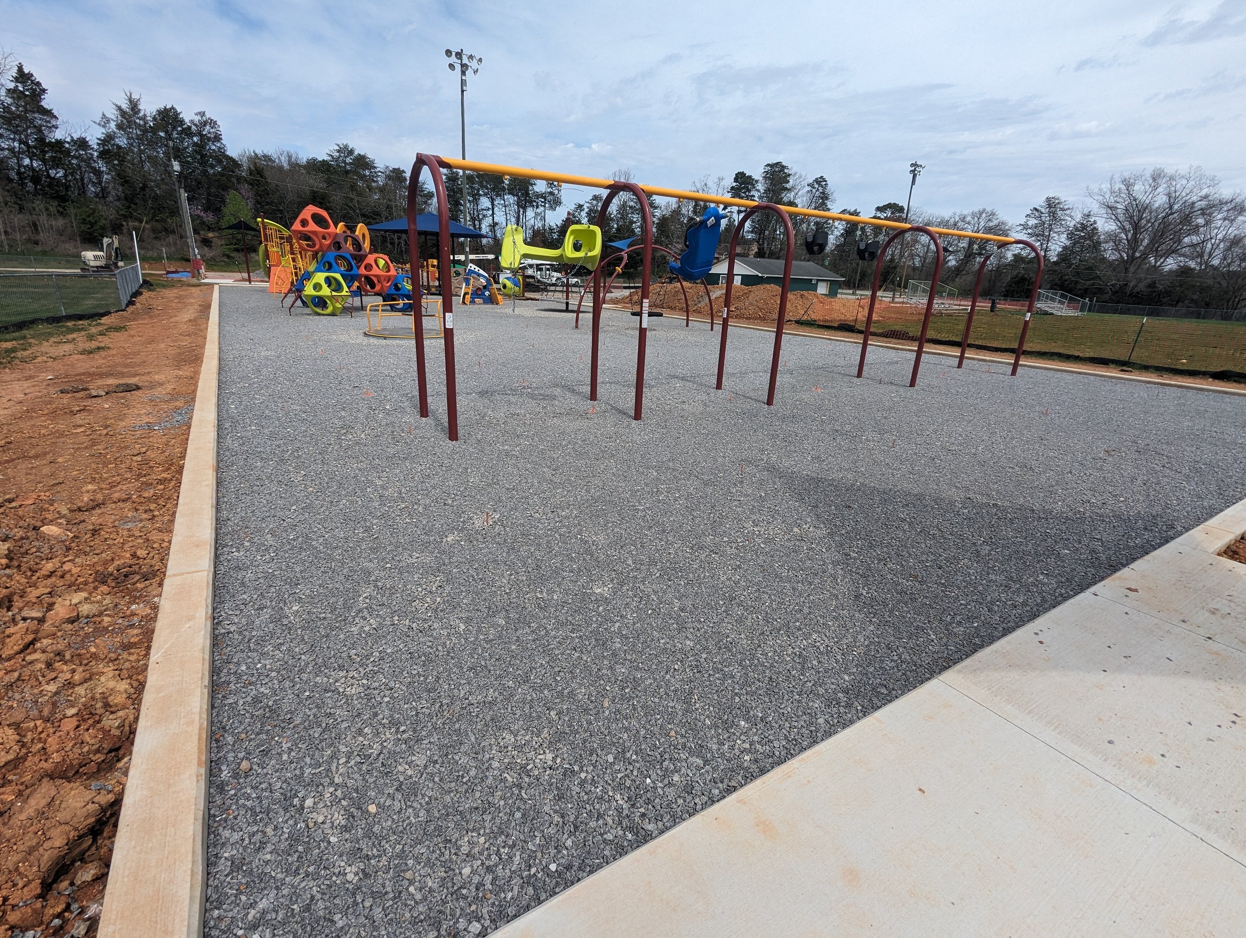 3/21/2024 - Crews fine tune the grading for the stone that lies under the playground surfacing to ensure proper drainage and ADA compliant slopes.