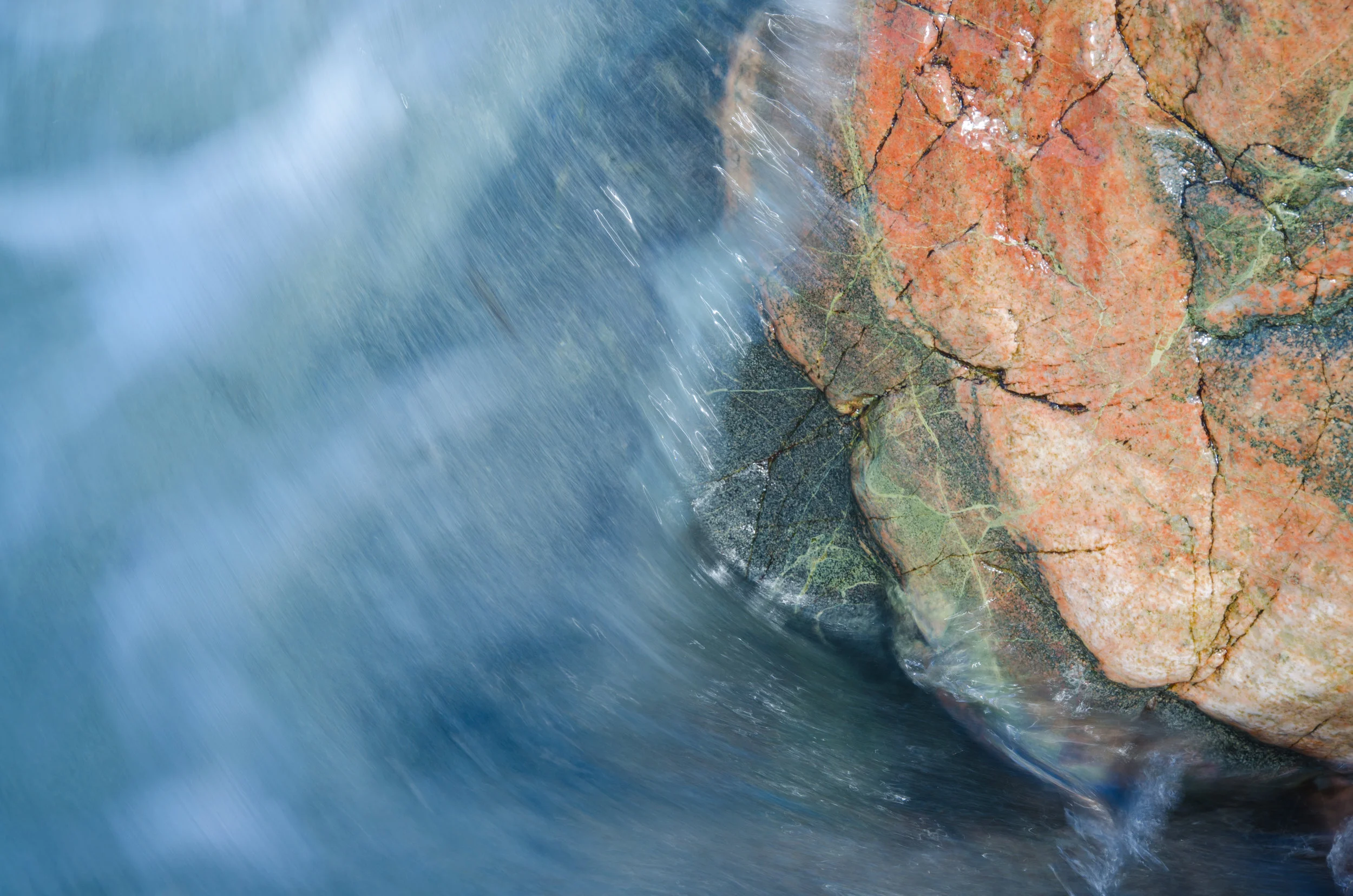 Water rushes over one of the colourful rocks