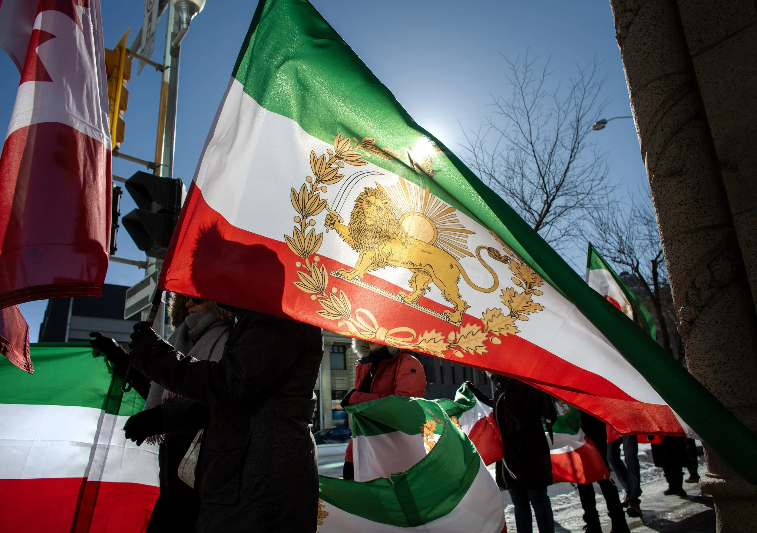 The flag of pre-revolution Iran is held during a rally for freedom by Iranian activists, Sunday afternoon in Winnipeg, Manitoba, Canada.