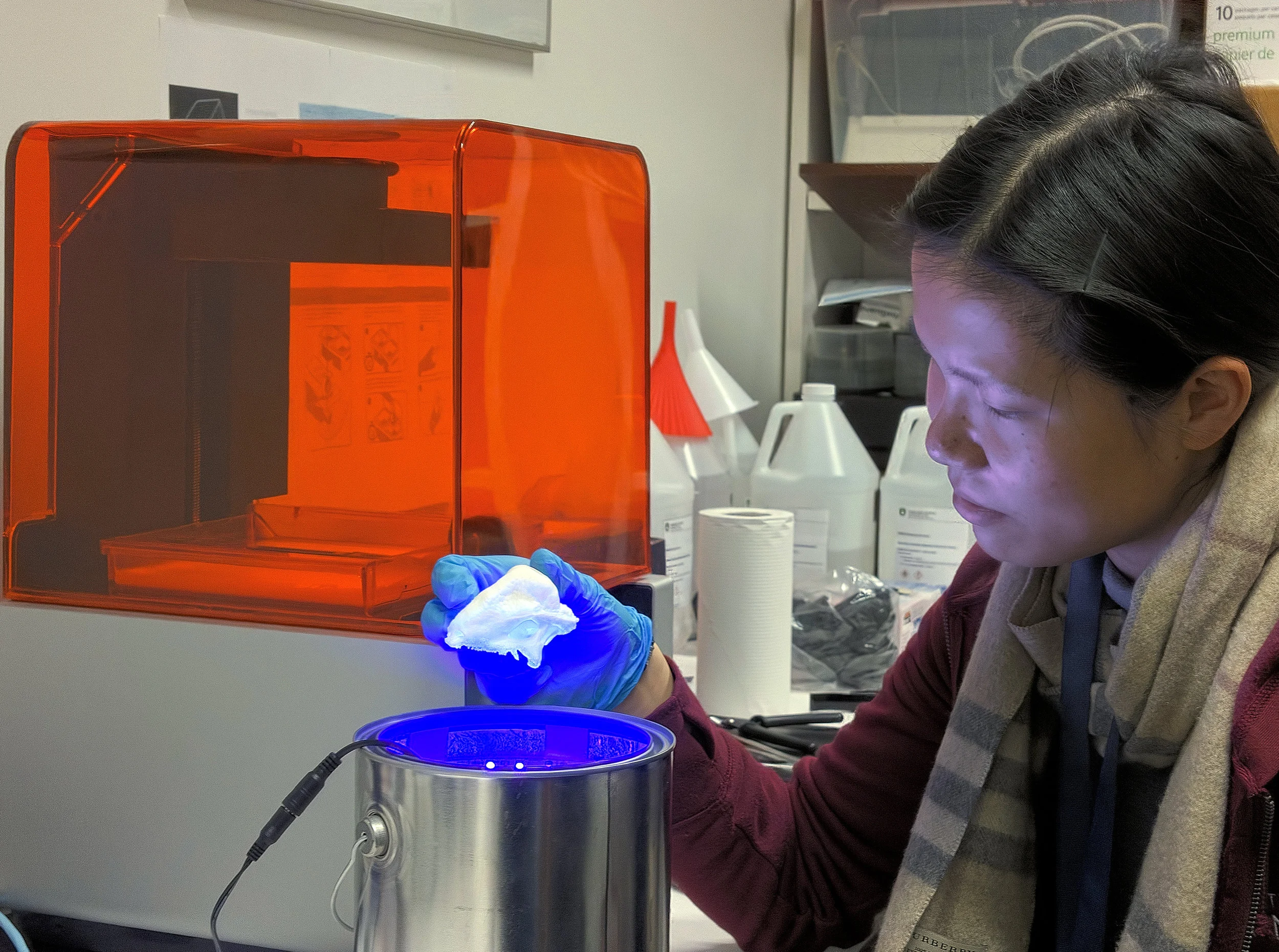 BMC student Christine Shan examining a cured 3D print.