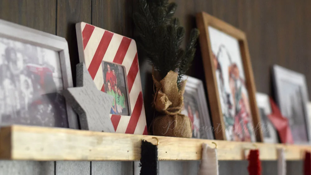 Shelf for Christmas pictures with hooks for stockings