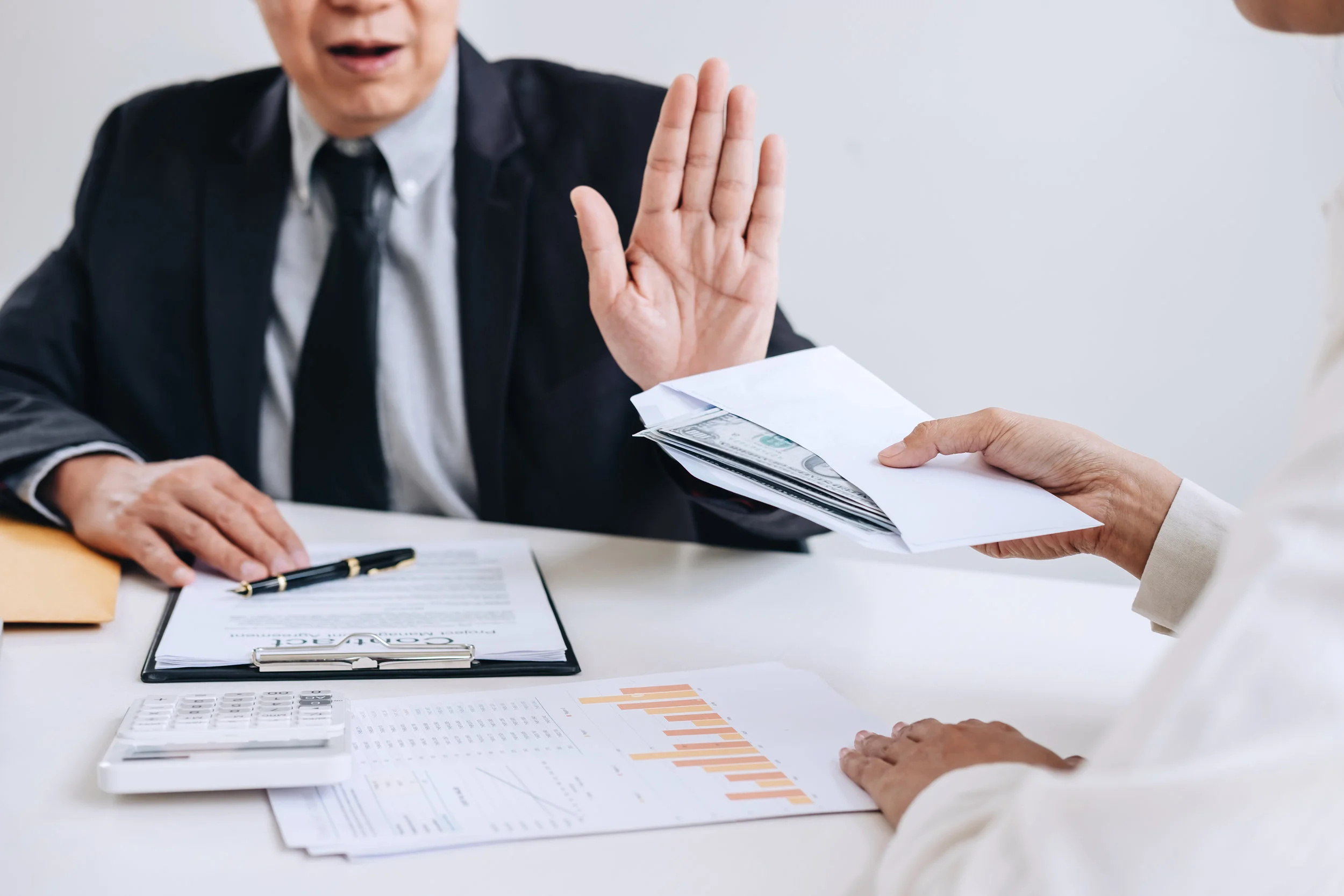Canva - Bribery and corruption concept, senior businessman manager refusing receive money in the envelope to agreement contract, A bribe in the form of dollar bills.jpg