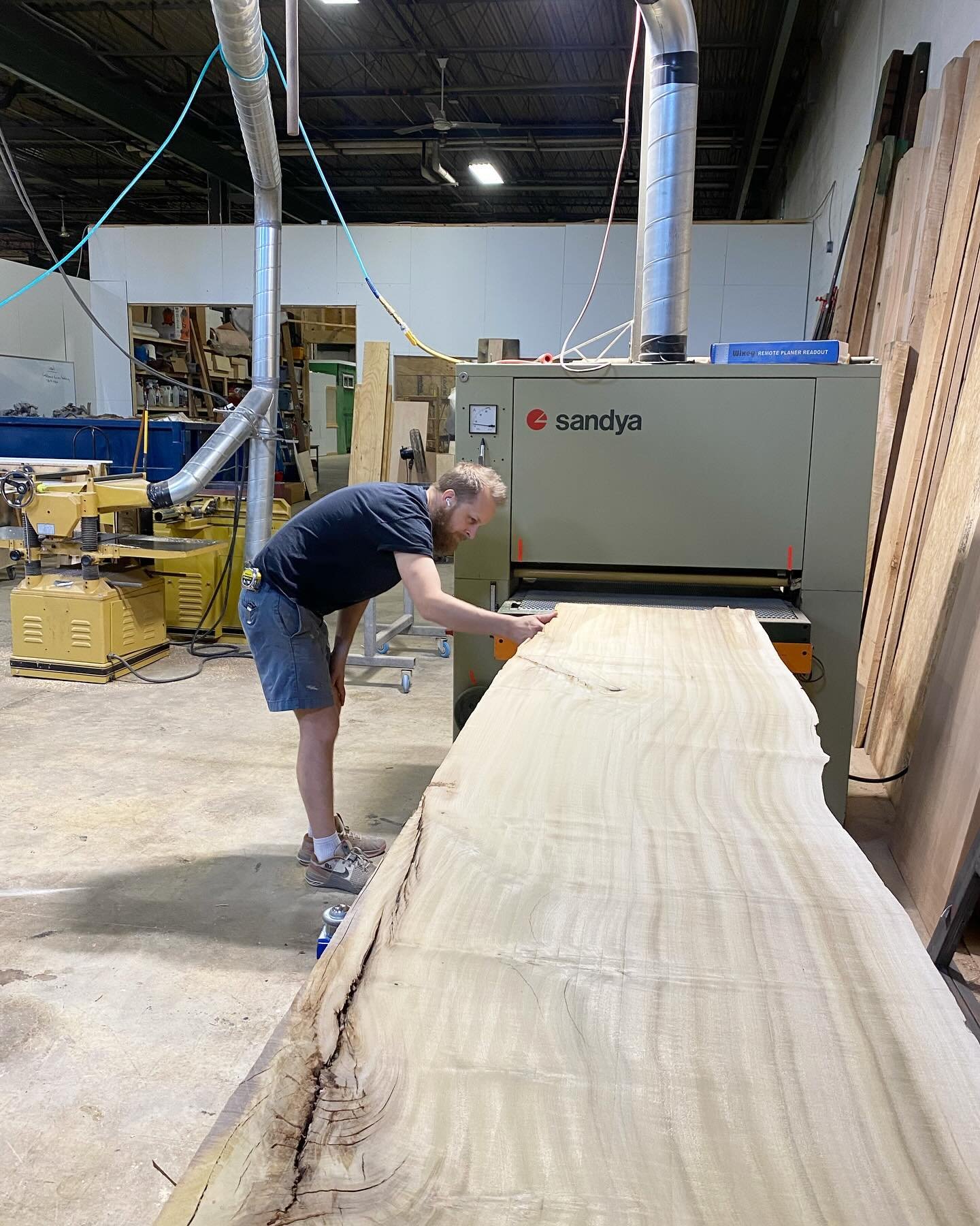 Massive poplar slab going through our wide belt sander. This was after we cut it in 1/2 lengthwise, the whole slab was too wide for the room so we took 12&rdquo; out of the middle. 😬
