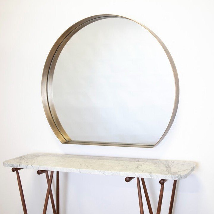 Solid brass Benjamin mirror above a Maeve console table in white Venatino marble and walnut.