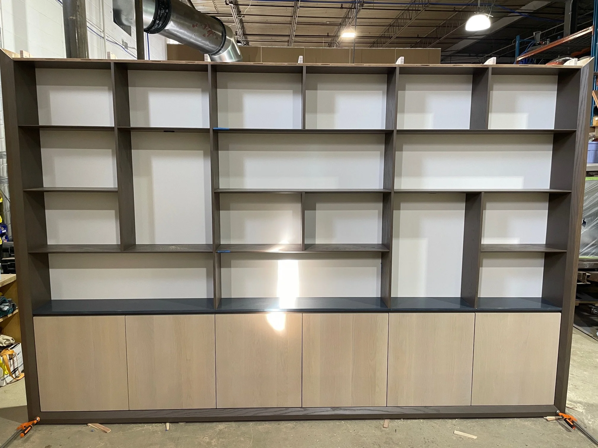 A 13' long bookcase in white oak and lacquered maple, with integrated lighting. Delivered back in April. It had to be built in three 52" wide sections to fit in the elevator, with full length 13' long top and bottom face frames so no seams were 