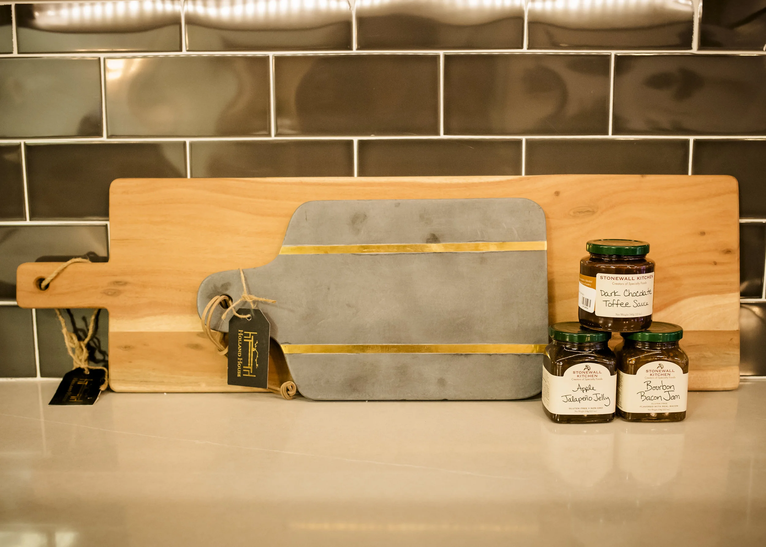 Oversized Wood Cutting Board $100, Gray Glimmer Cutting Board $45, Dark Chocolate Toffee Sauce $8, Apple Jalapeño Jelly $8, Bourbon Bacon Jam $8