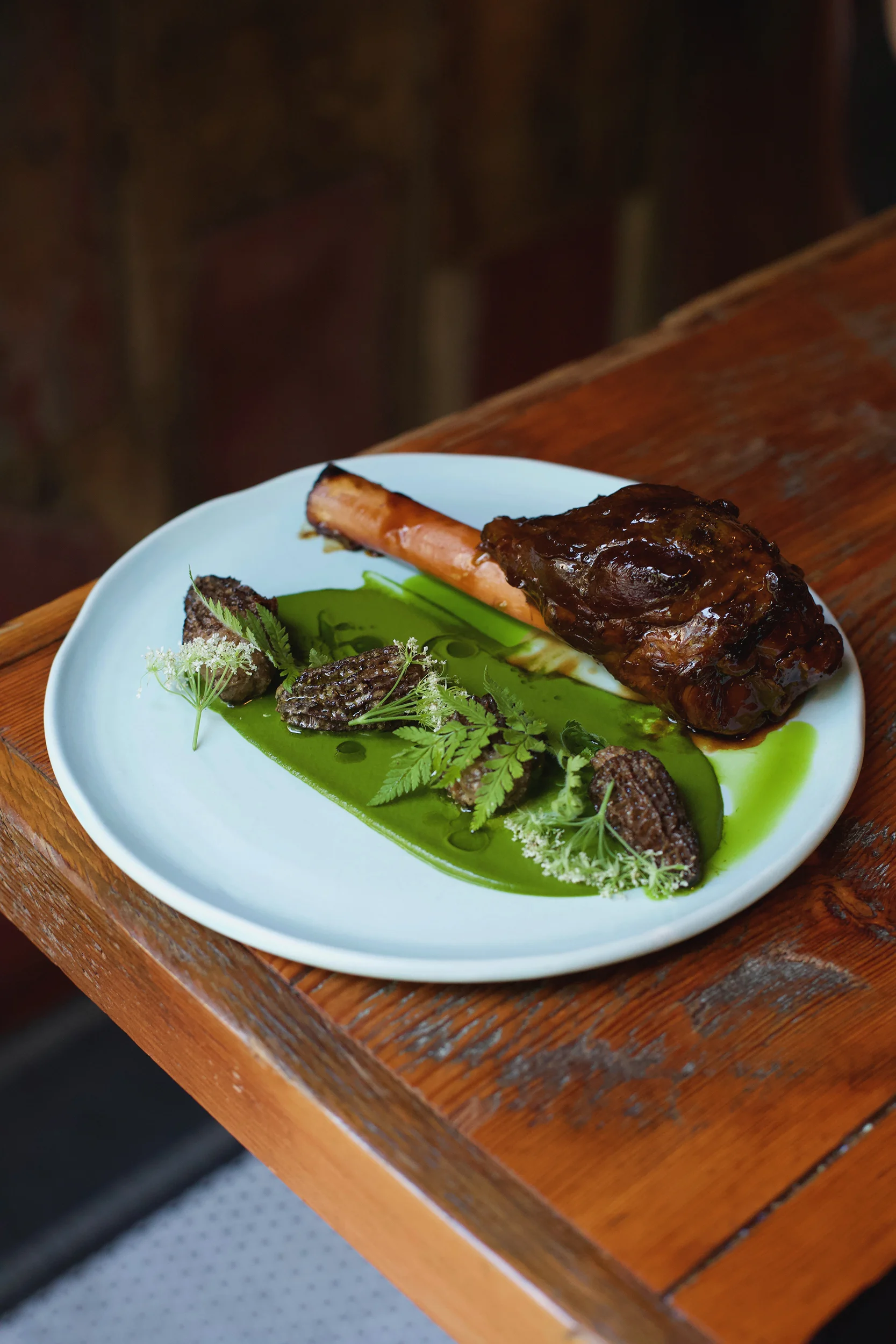 Peace Country Lamb Shank, foie gras-stuffed morels, leek, and foraged sweet cicely.