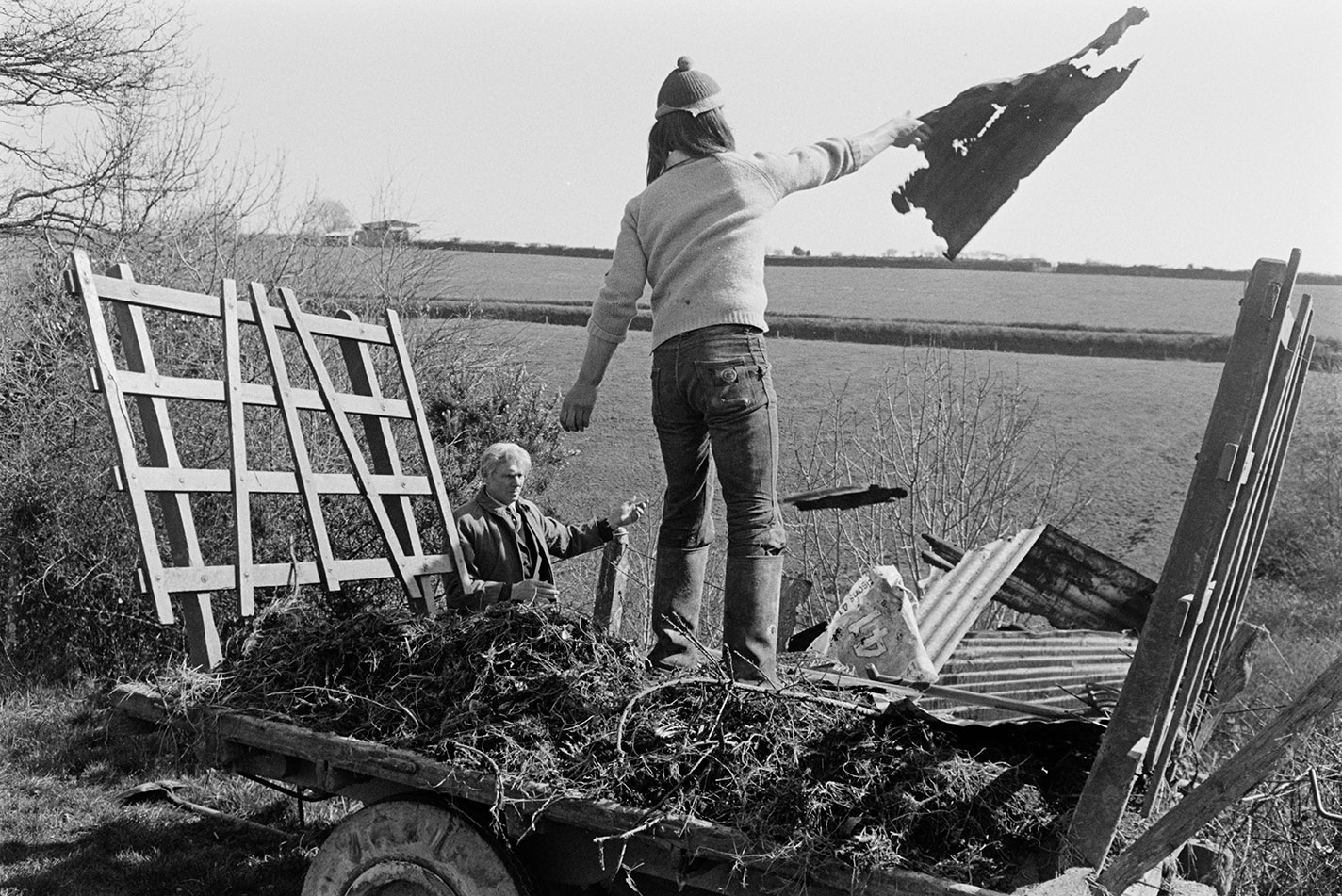 Throwing old corrugated iron sheets into field / scrubland, Beaford, March 1972