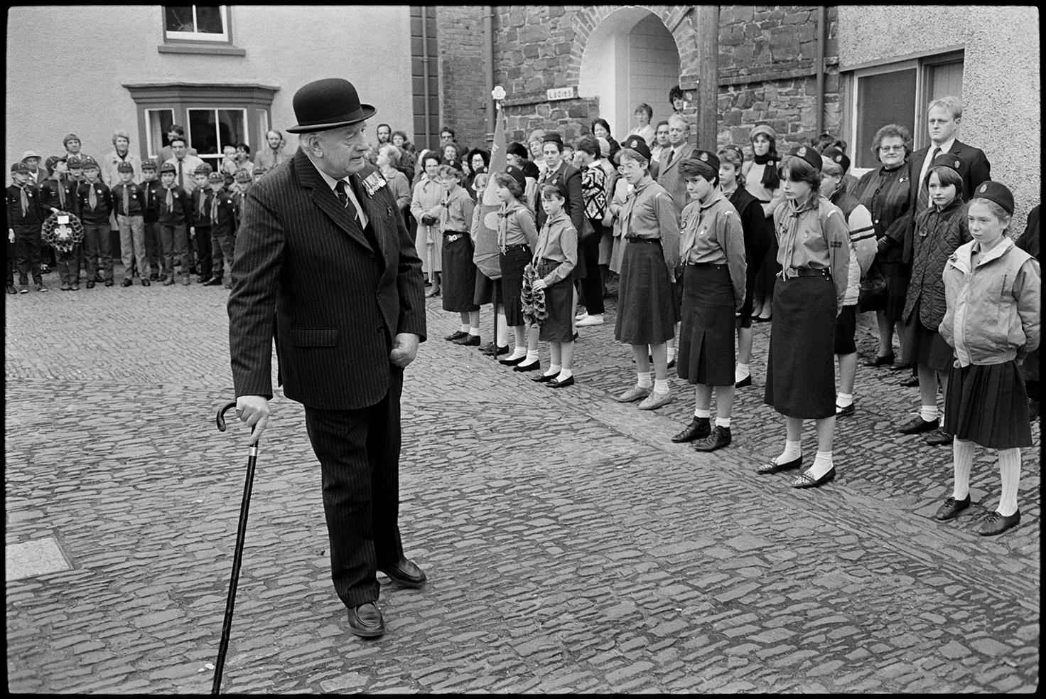 Men & women assembling for Remembrance Sunday Parade. Chulmleigh, November 1981