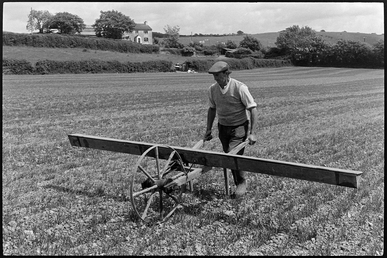 Farmer using old seed drill. Beaford, Balls Farm, June 1975. Documentary photograph by James Ravilious for the Beaford Archive © Beaford Arts