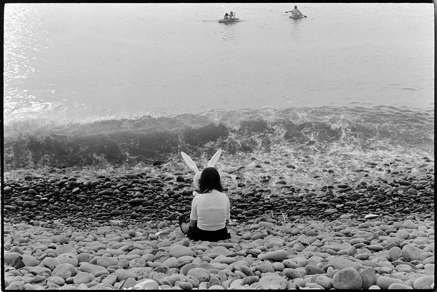 Girl on beach with rabbit ‘mask’, Westward-Ho!, August 1973. Documentary photograph by James Ravilious