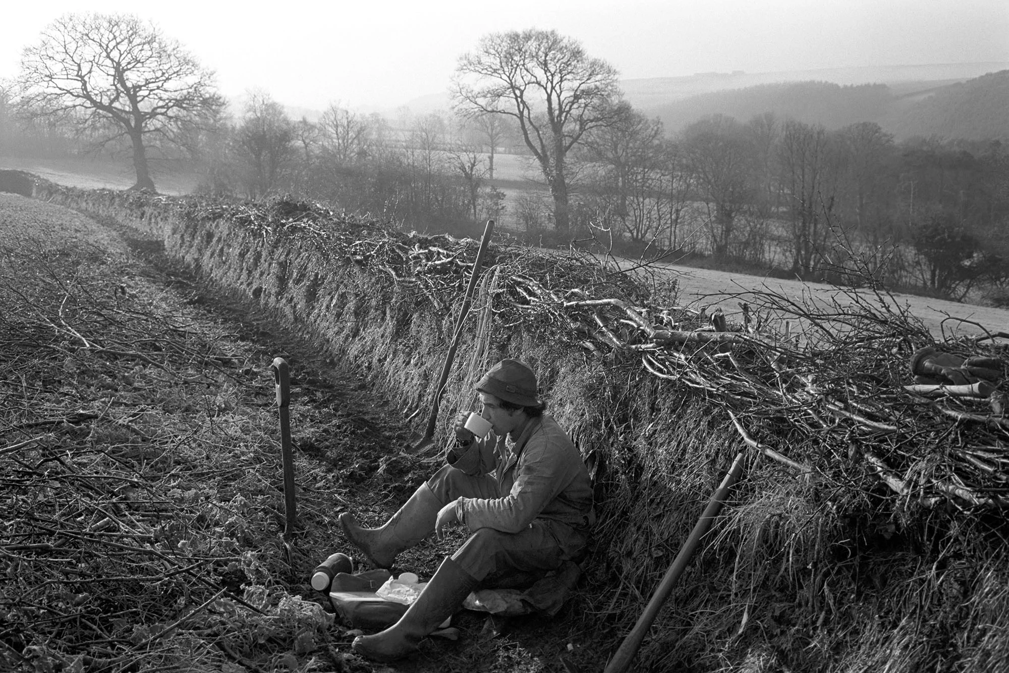 ‘Hedger’s Lunch Break’ taken in Langham, Dolton, 1980 by James Ravilious for the Beaford Archive