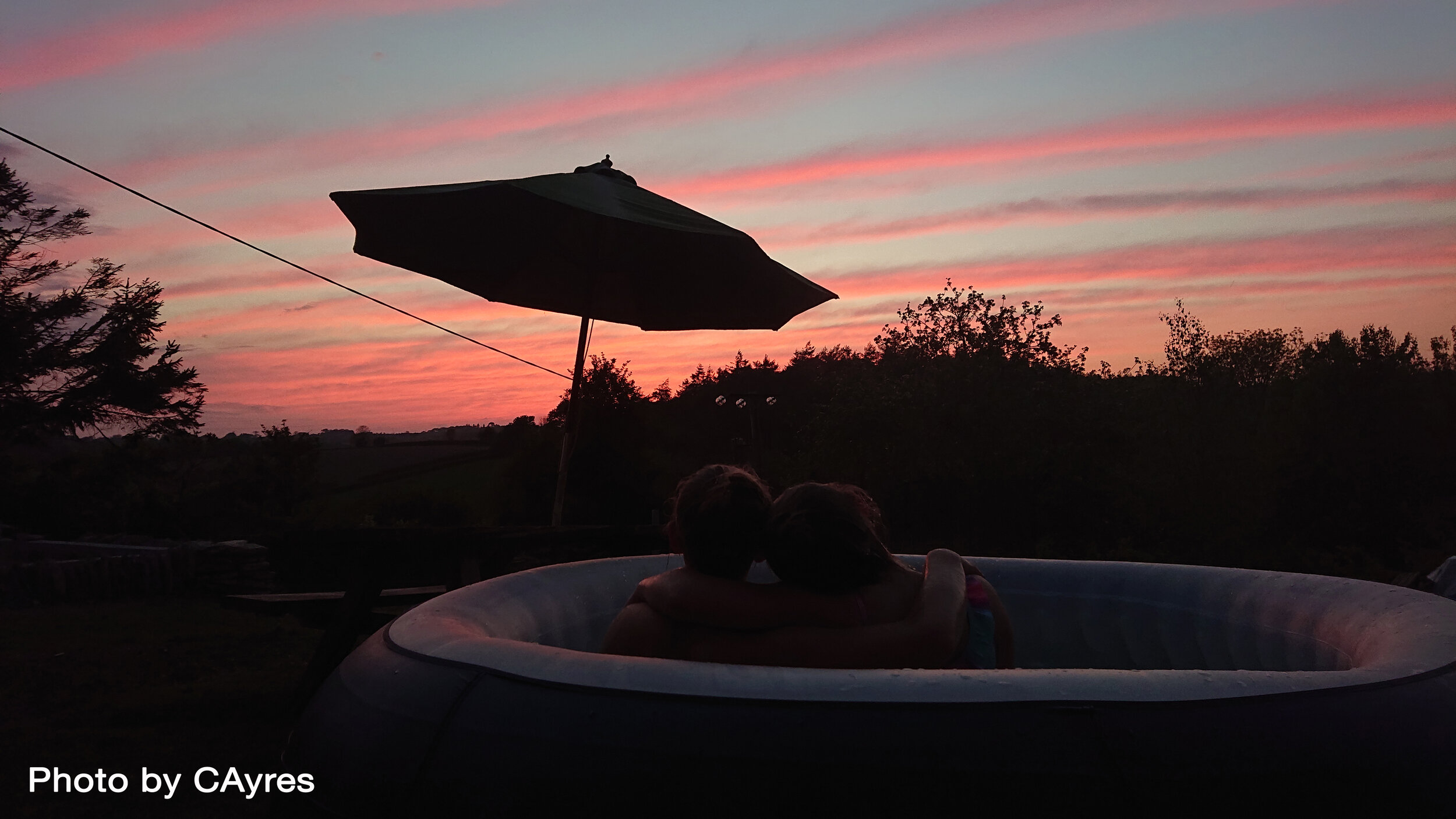 CAyres Sisters relaxing in hot tub with sunset Tawstock 040520.JPG