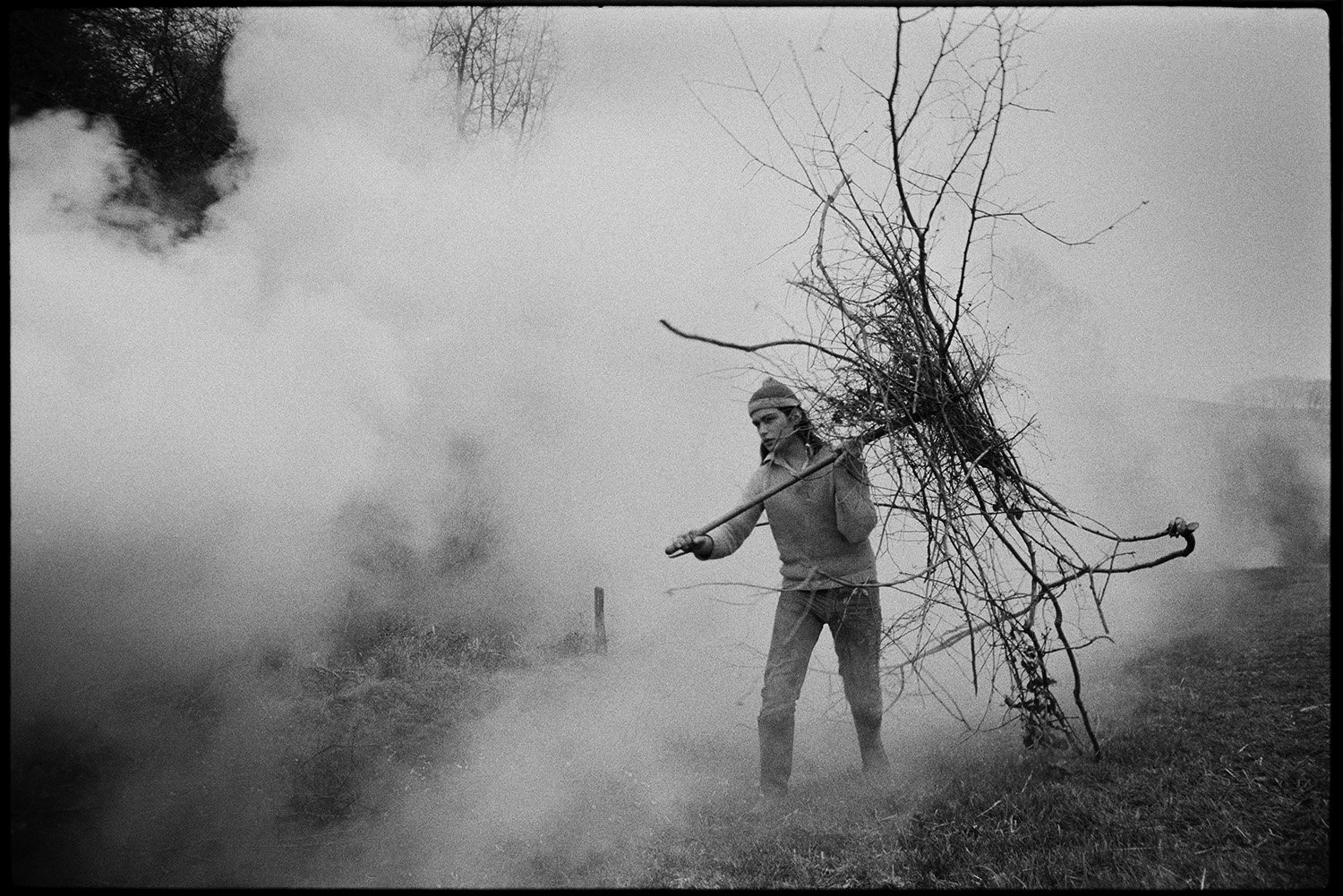 Derek Bright bringing cuttings from hedge steeping or laying on a fork to be burnt, Mill Road Farm, Beaford, 1971. Sir Roger Deakins CBE