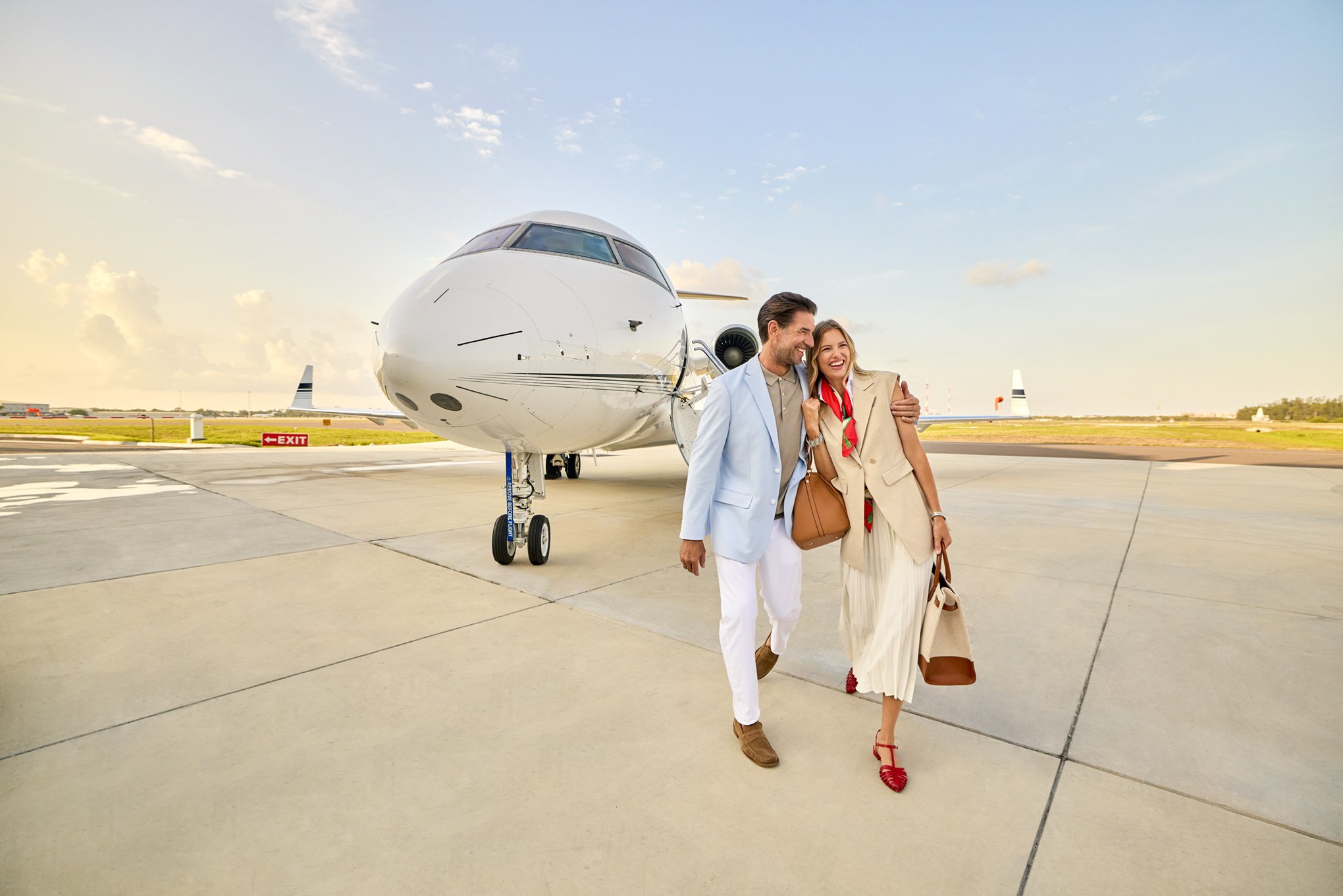 Couple walking from a private jet on the runway in Naples Florida — luxury travel arrival scene photographed for Florida’s Paradise Coast tourism campaign.