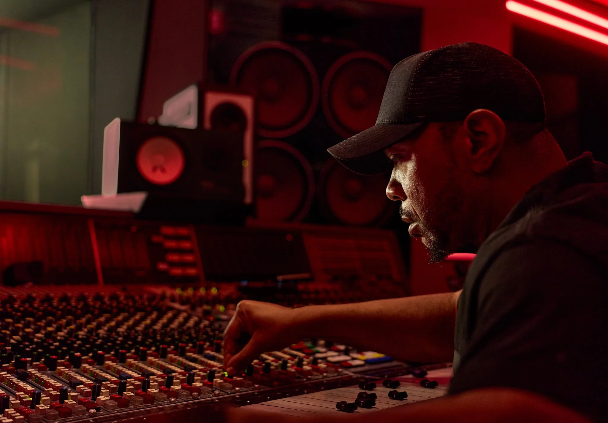 Environmental portrait of Timbaland working at the recording studio mixing console.