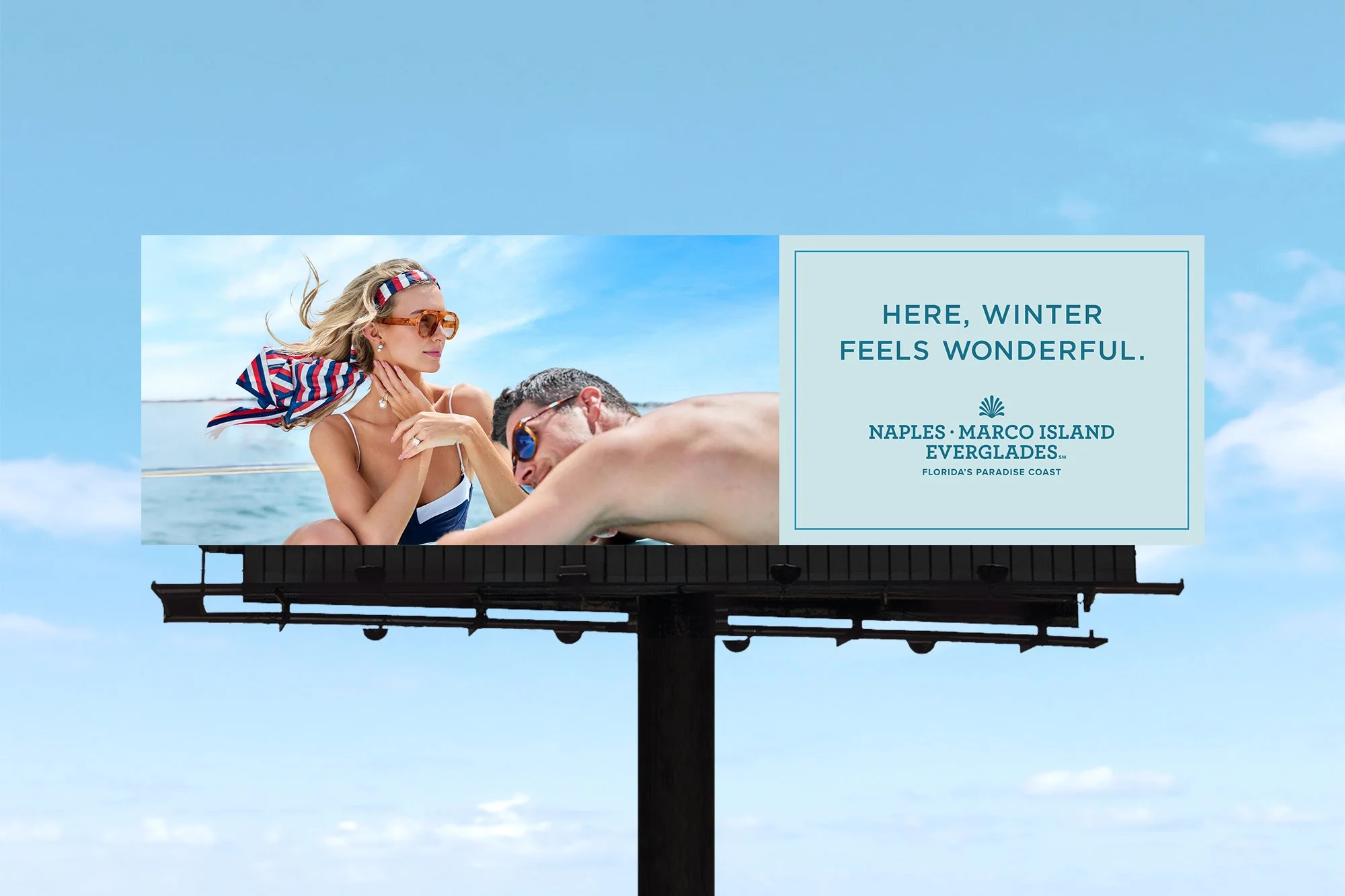 Florida’s Paradise Coast tourism campaign displayed on a large outdoor billboard featuring luxury boating lifestyle imagery.