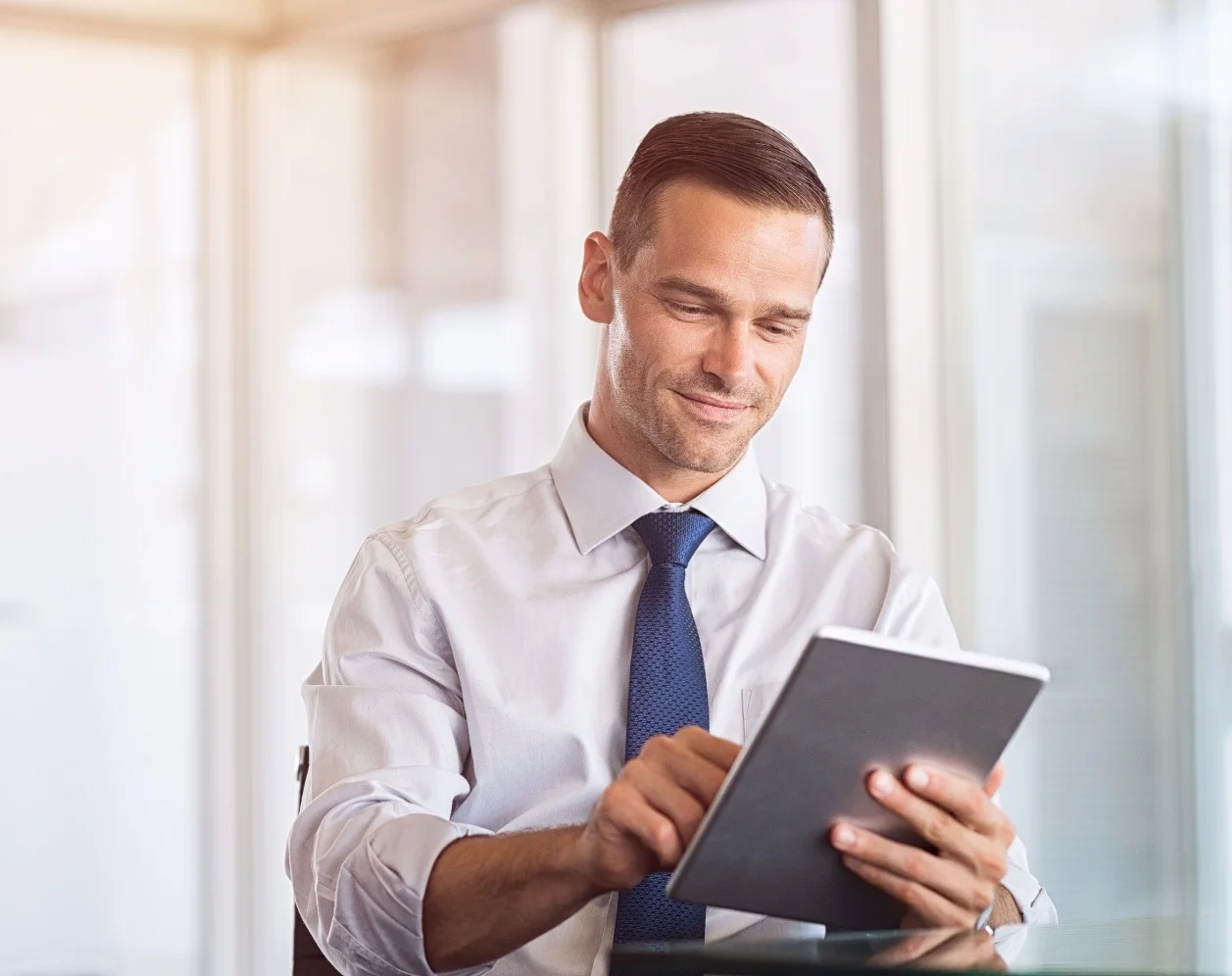 Smiling businessman using digital tablet at work. Portrait of a happy formal man working on computer_edited.jpg