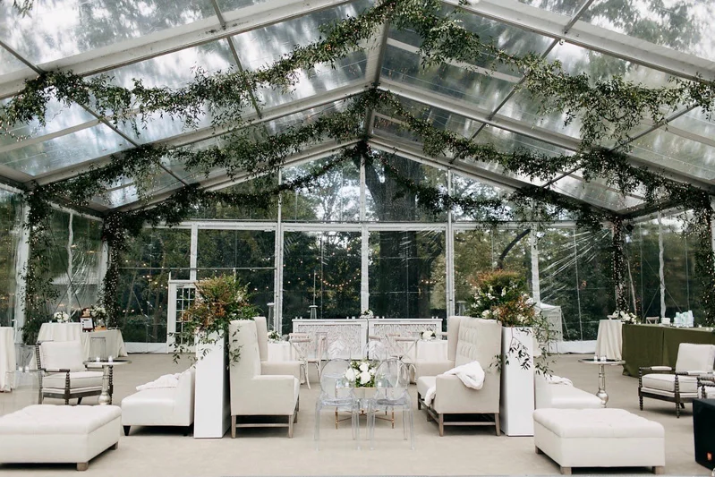 banquettes, club chairs, ivory ottomans, clear tent