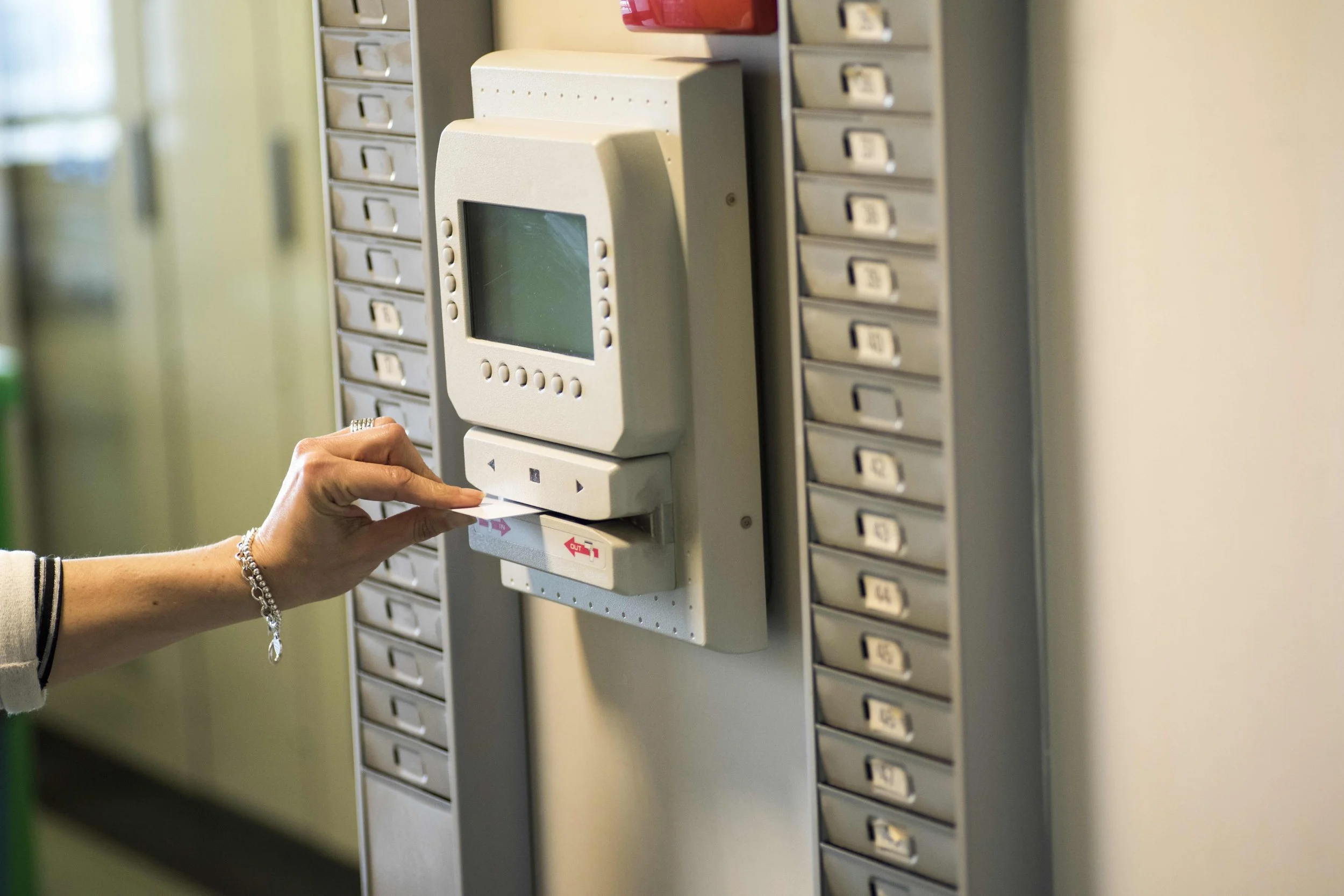 Person using a punch card to access a device at a locker system.