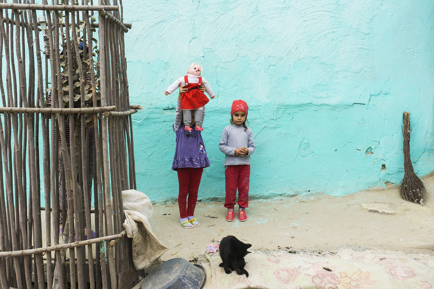  PhoS Sofia Street Photography Days, Bulgaria, 2019  I took this photo being drawn by the colour of the house waIls of a poor family from the southern part of Romania and discovering in that courtyard a part of the world of 2 girls playing with their