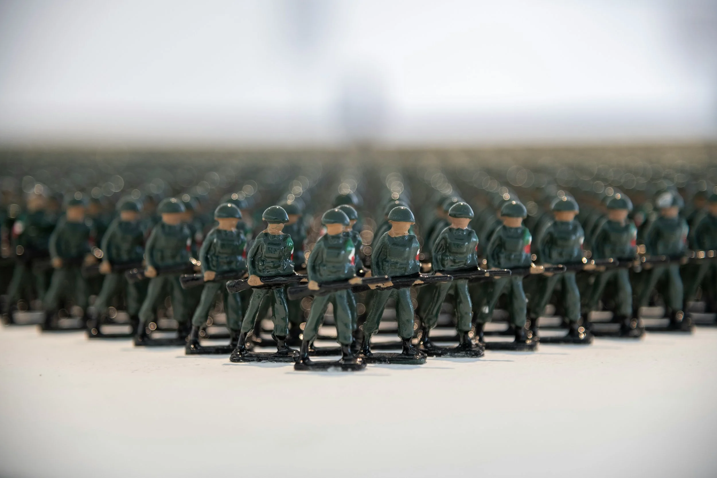 Plastic toy soldiers holding rifles arranged in a V-shaped formation.
