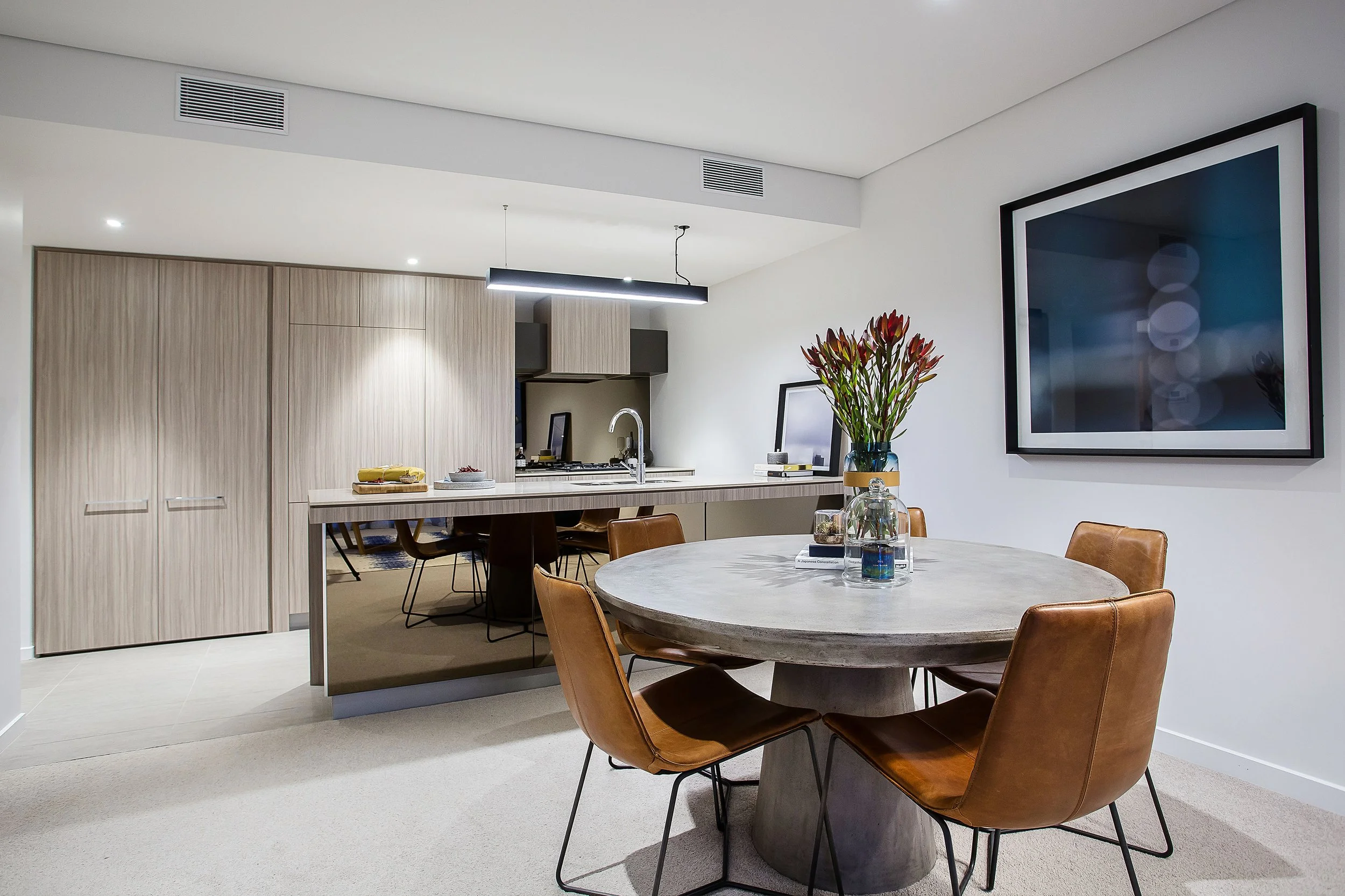 View from dining area to kitchen in Forge Docklands Apartment 204 highlighting open plan layout and timber cabinetry.