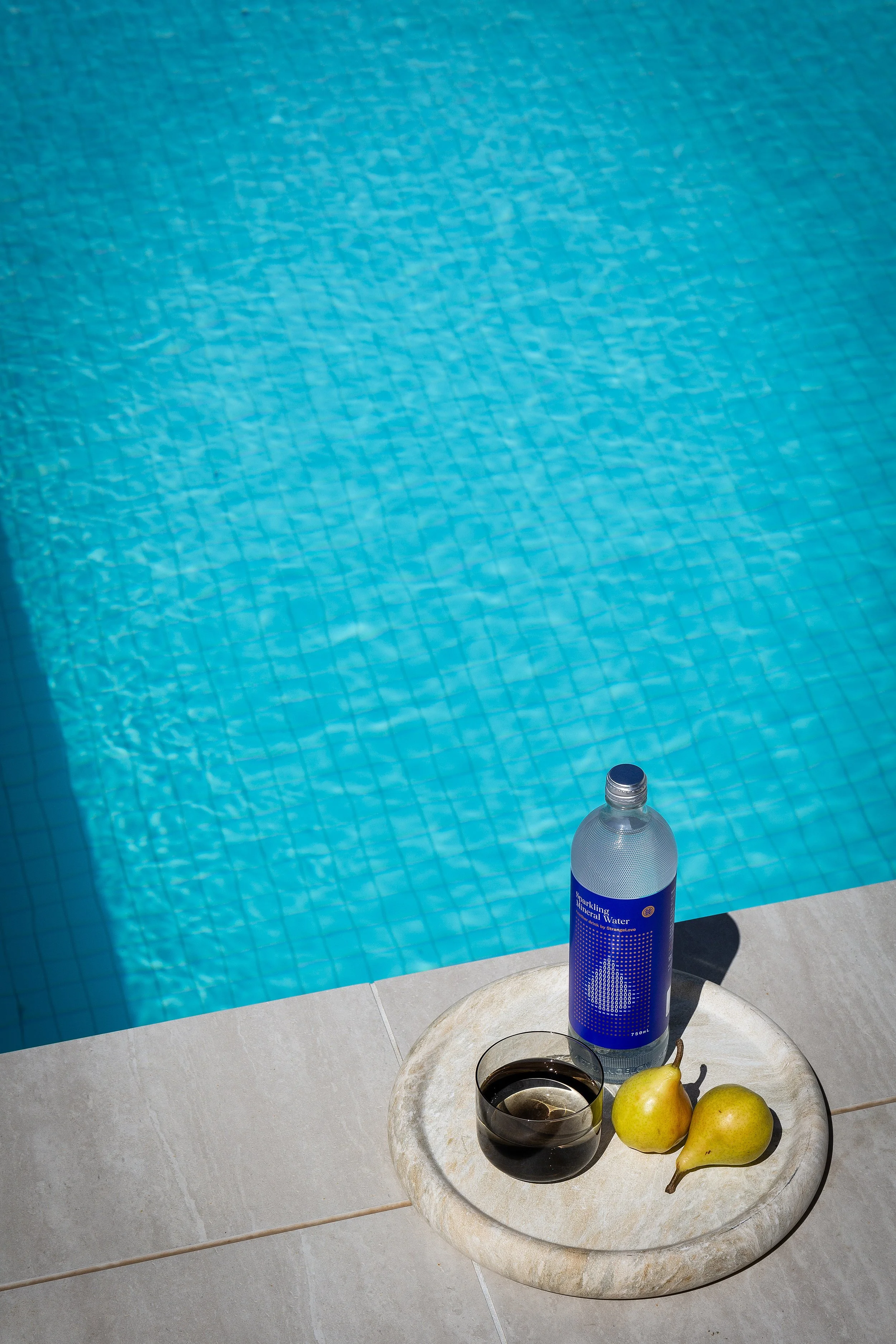 Poolside styling detail with stone tray, mineral water, glass and pears at Dromana residence