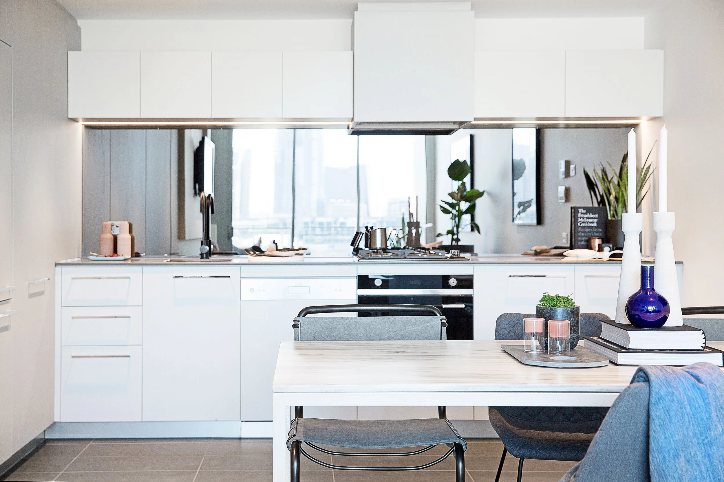 Open plan kitchen and dining space styled in a restrained urban palette to appeal to design-savvy buyers seeking contemporary loft living in Melbourne.