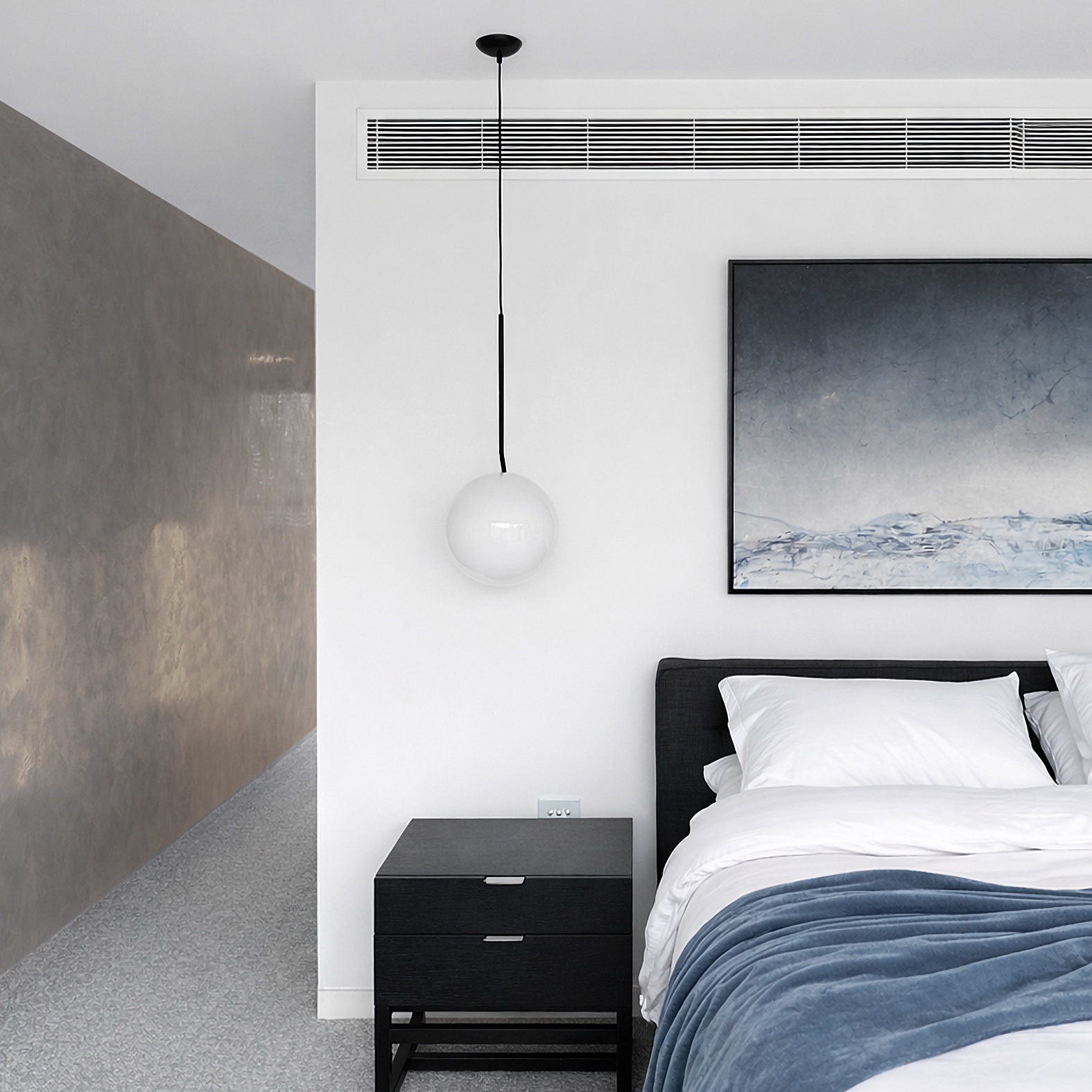 Minimal bedroom styling with soft grey finishes and layered textures creating calm contemporary luxury.