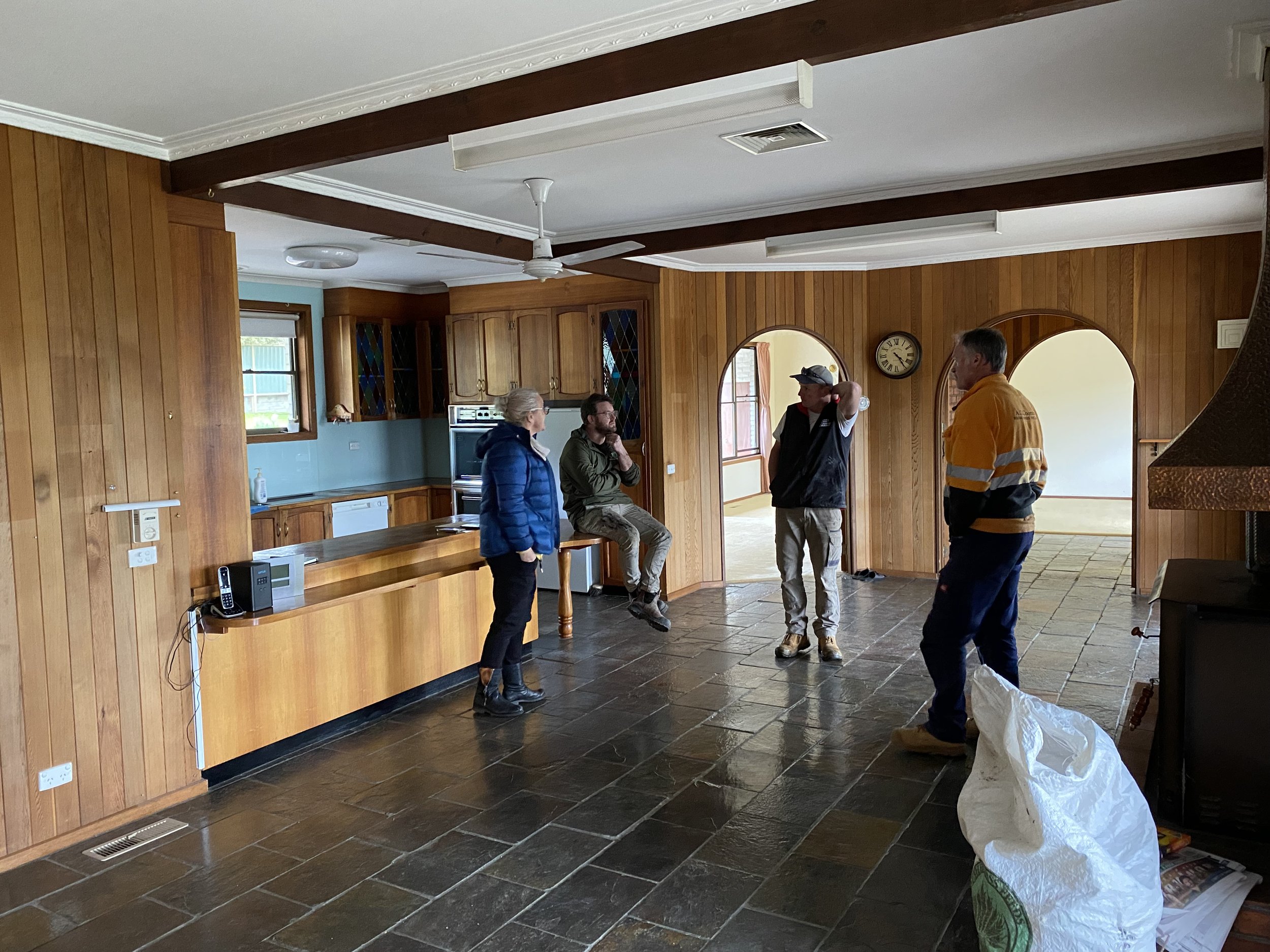 Dromana renovation before image of open plan kitchen and living area with timber cabinetry and slate flooring