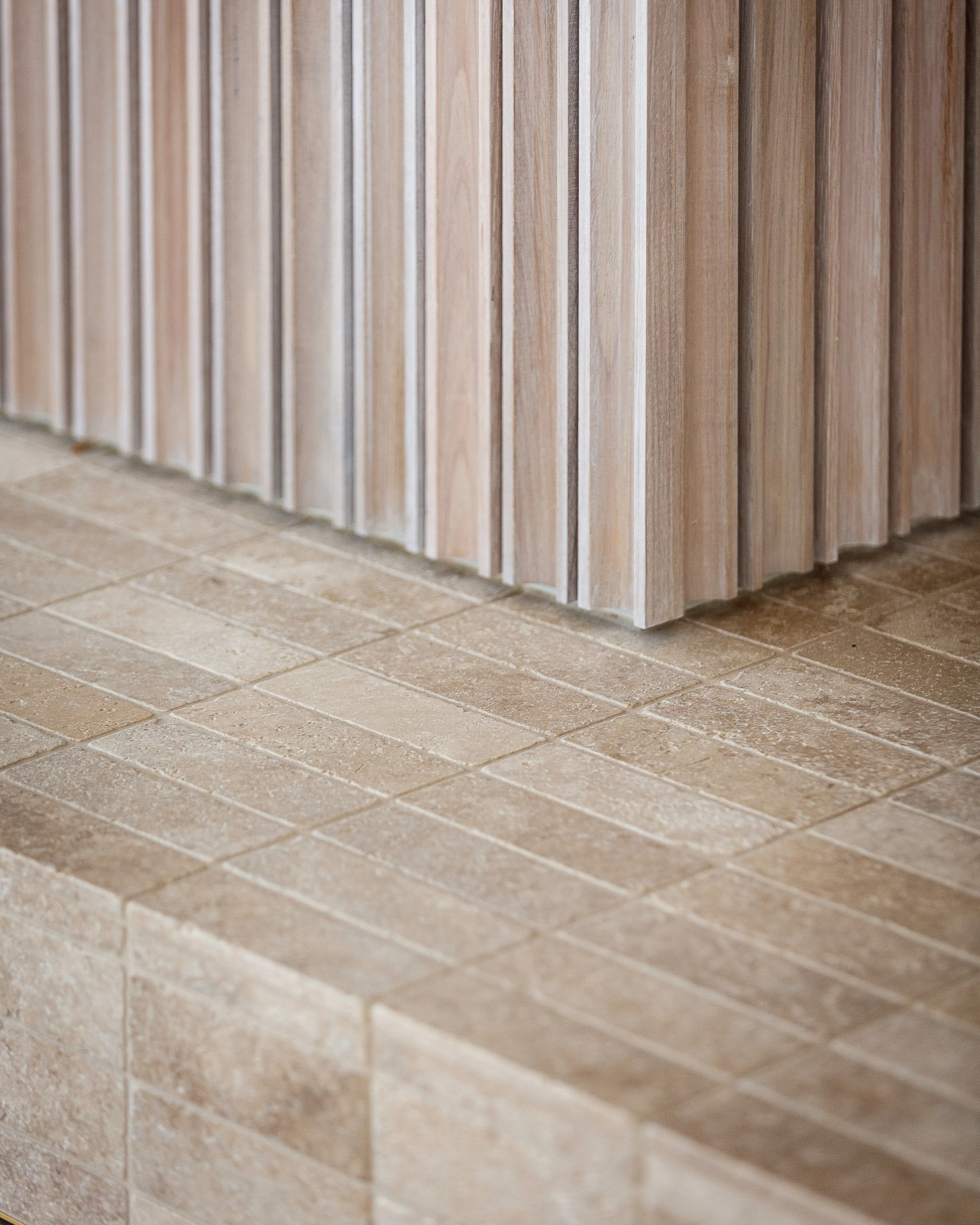 Detail of curved fluted timber wall and timber dining chair in Dromana residence