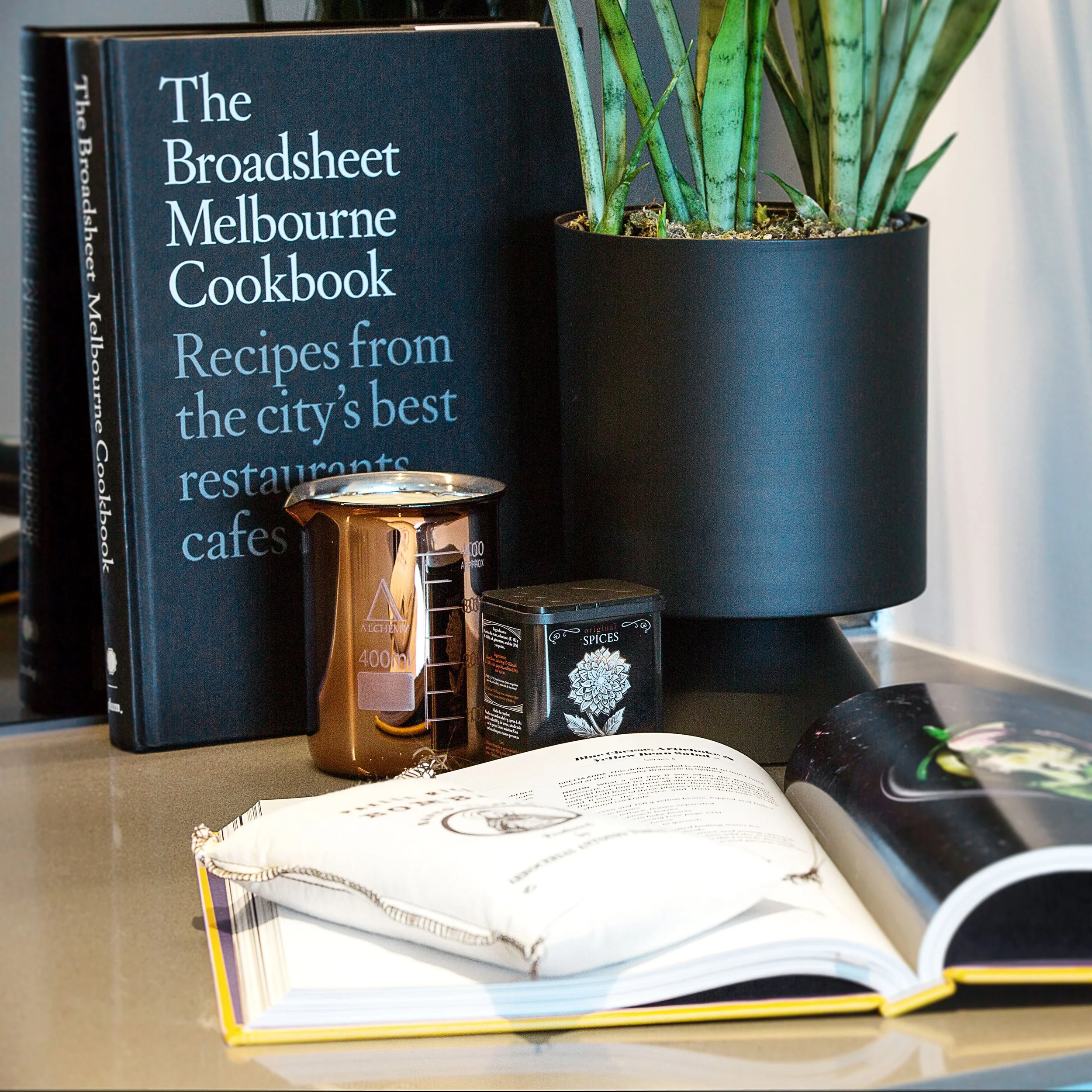Dining and kitchen styling featuring Melbourne Cookbook, curated accessories and indoor greenery, reinforcing a local lifestyle narrative at Forge.