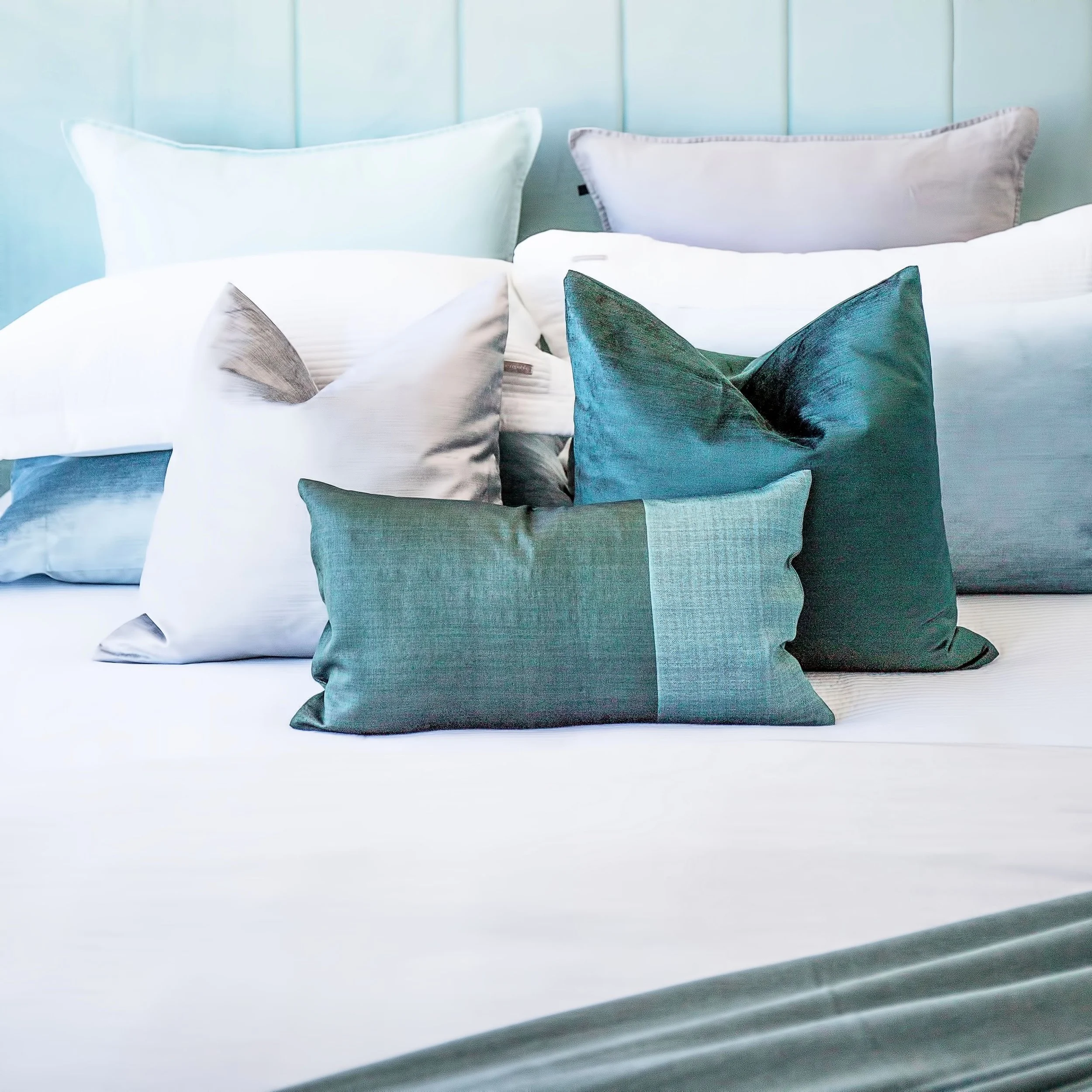Close up of layered bedroom cushions and soft furnishings in Forge Docklands apartment 1057.